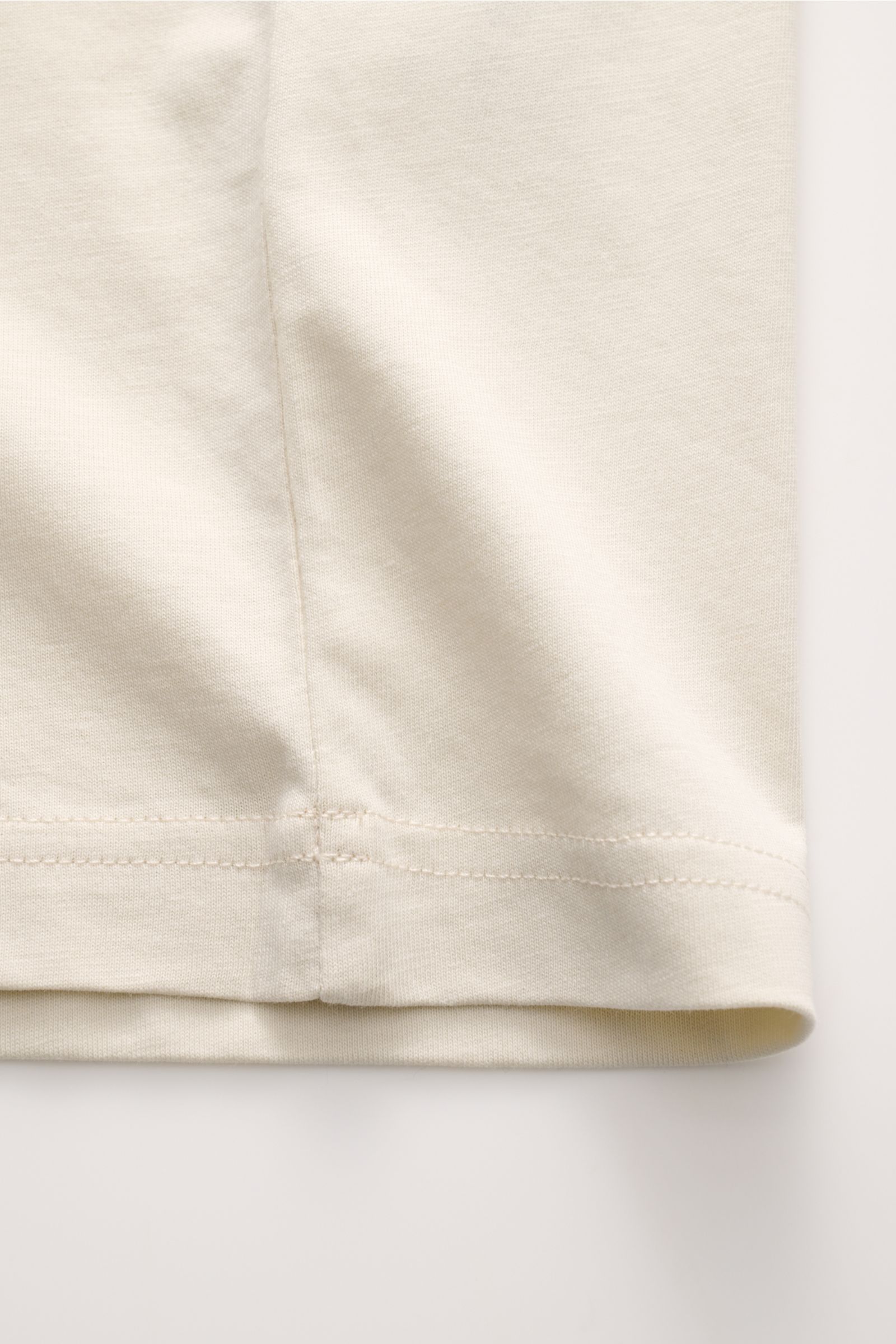 Nahaufnahme des Saums vom Belstaff Rundhals-T-Shirt creme aus weichem, leichtem Baumwoll-Jersey mit tonalem Weblabel, Slim Fit.