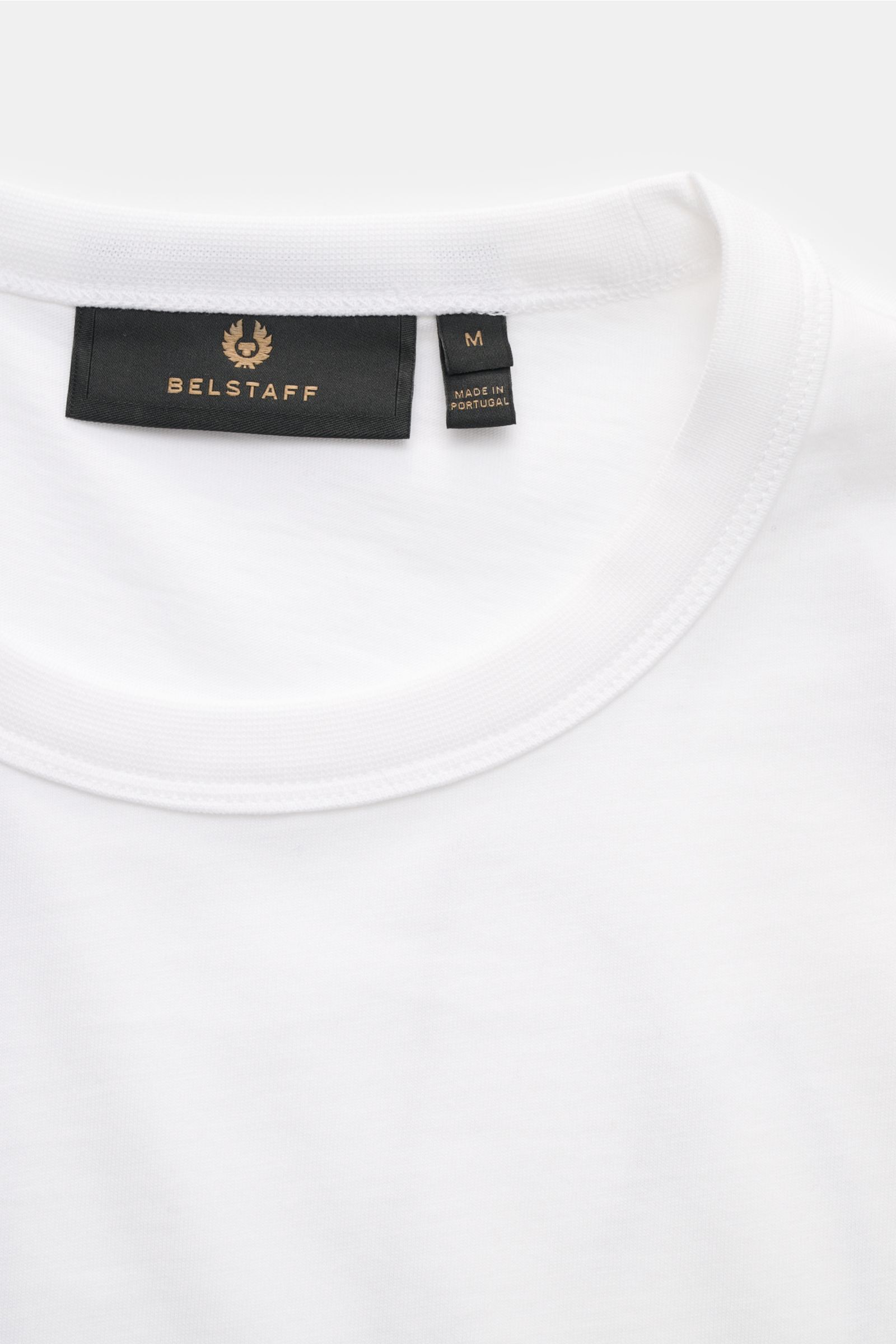 Close-up front view of the neckline and label of the Belstaff Rundhals-T-Shirt 'Border' weiß, a white cotton regular fit T-shirt with a soft feel.

Das Rundhals-T-Shirt 'Border' von BELSTAFF zeigt sich im Regular Fit mit markantem XXL-Phönix-Logo auf d