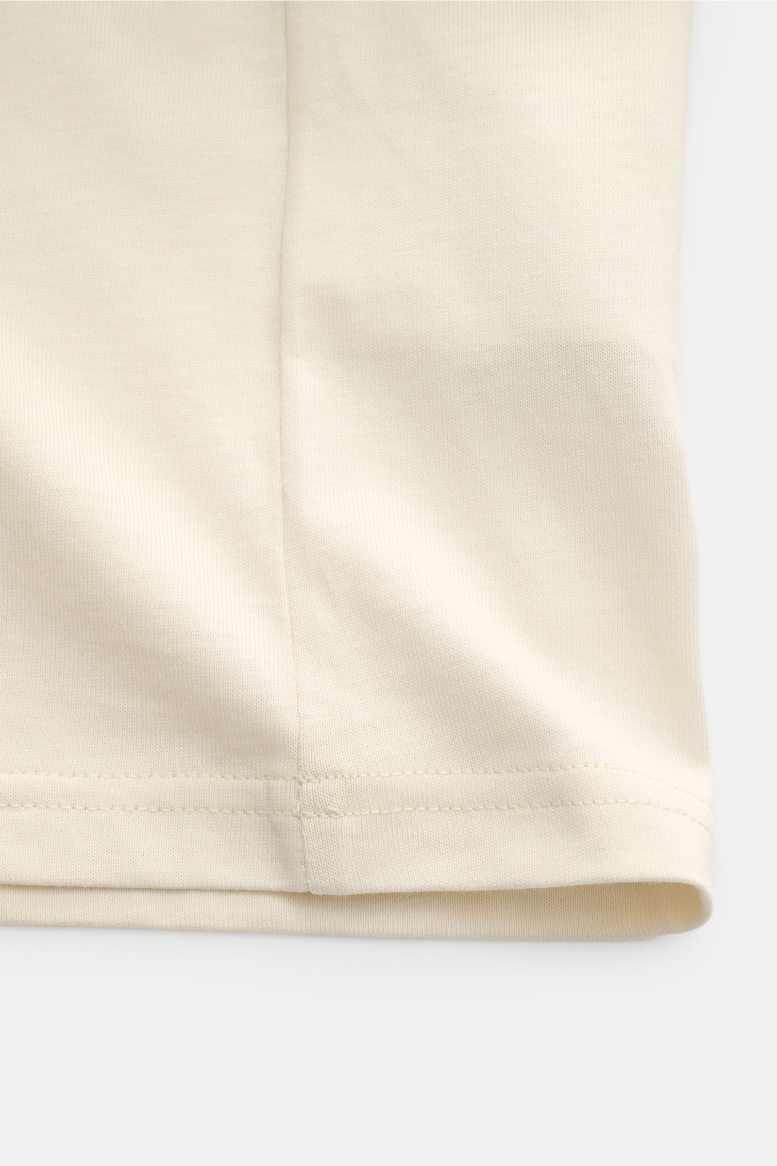Beige Belstaff Rundhals-T-Shirt 'Shadow' shown from a close-up side angle, highlighting soft pure cotton jersey fabric and fine stitching. Das 'Shadow' T-Shirt von BELSTAFF ist ein vielseitiges Basic mit sportivem Charakter. Gefertigt aus weichem Baumw