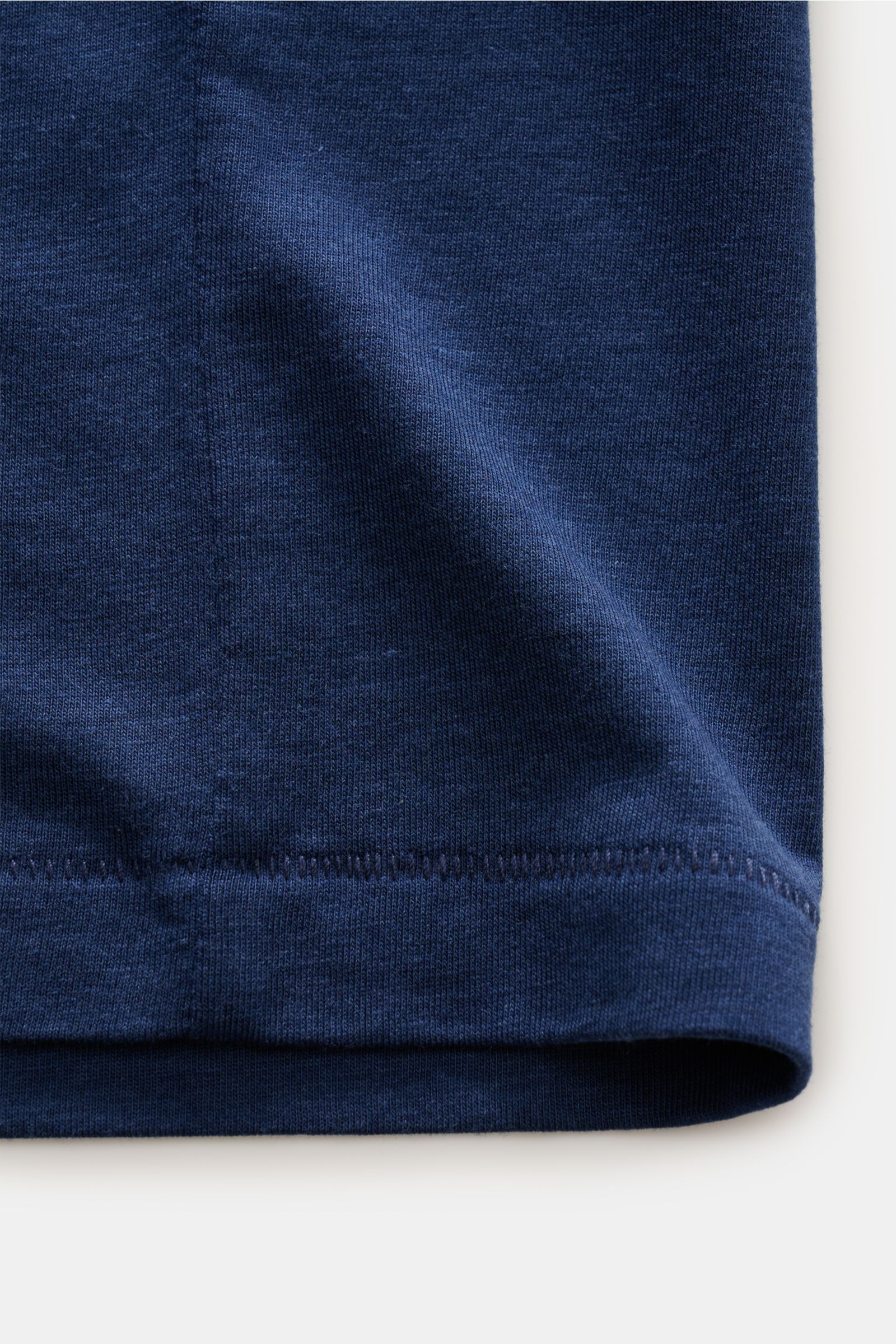 Close-up front view of the hem of the Tom Ford Rundhals-T-Shirt dunkelgrau, showing soft, lightweight fabric and neat label-stitching.

Description: Clean, aber besonders hochwertig und leicht präsentiert sich dieses softe Basic-Essential aus Lyocell u