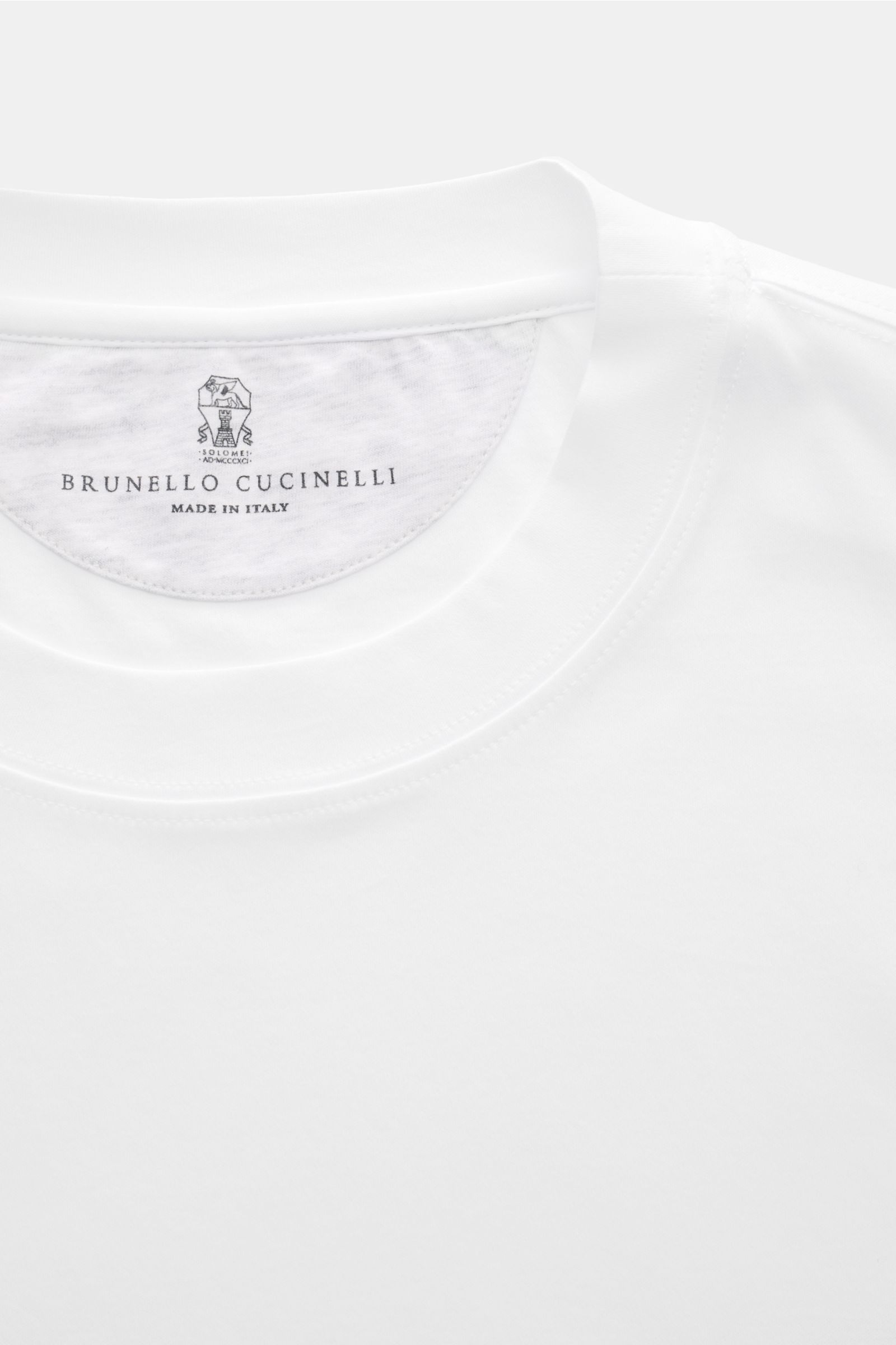 Close-up front top view of the Brunello Cucinelli Rundhals-T-Shirt weiß showing the round neckline and label, made of pure cotton jersey with soft touch, slim fit, and short hem slits. Luxuriöse Materialqualität und feinste Verarbeitung verleihen dem R