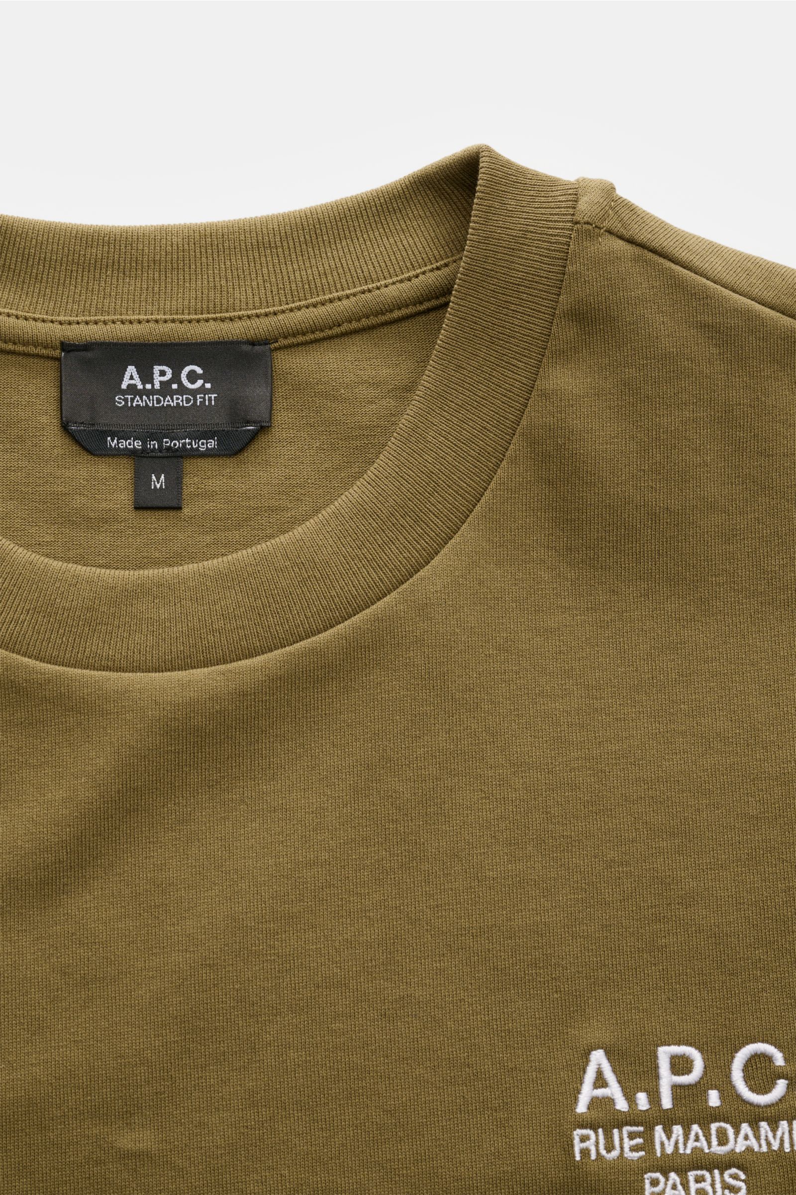 Close-up front view of A.P.C. Rundhals-T-Shirt 'Standard Rue Madame' oliv in olive green, showing round neckline and logo stitching.

Clean, cool, A.P.C. – das T-Shirt 'Standard Rue Madame' bringt französisches Understatement auf den Punkt. Aus weichem