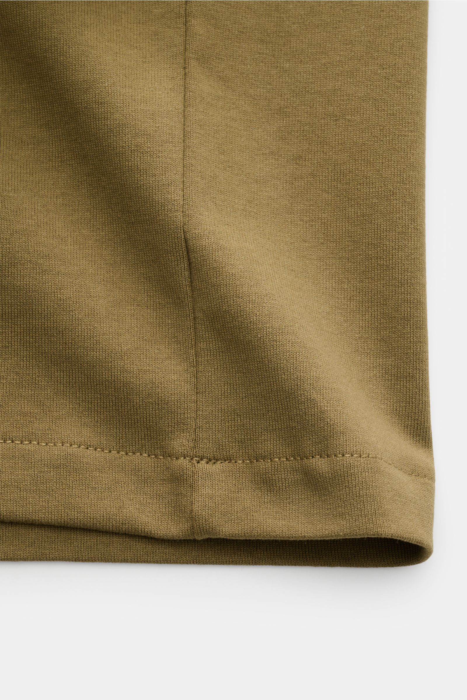A close-up front view of the hem and stitching detail of the A.P.C. Rundhals-T-Shirt 'Standard Rue Madame' oliv in soft olive cotton jersey. Clean, cool, A.P.C. – das T-Shirt 'Standard Rue Madame' bringt französisches Understatement auf den Punkt. Aus 
