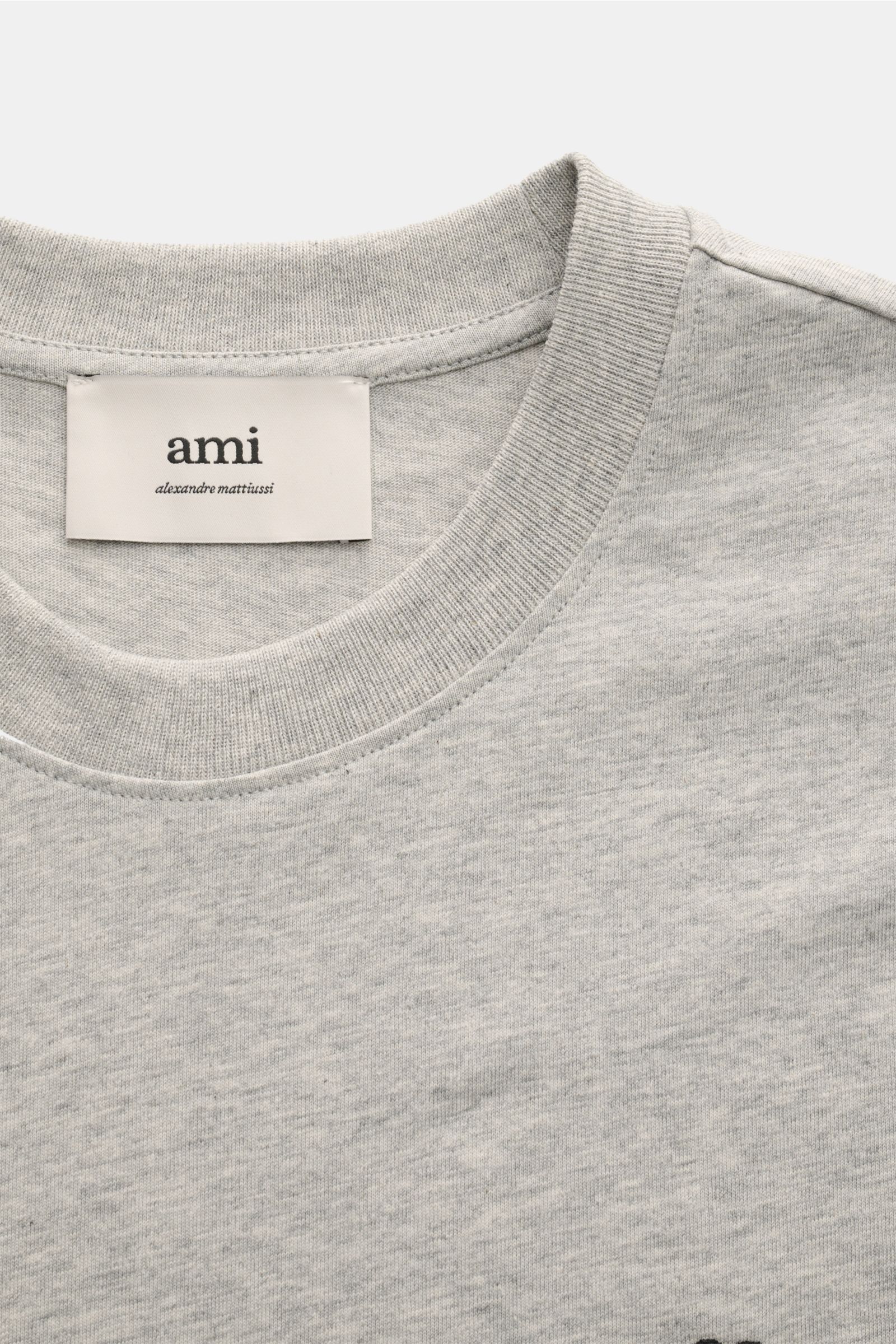 Ami Paris Rundhals-T-Shirt hellgrau aus weichem Baumwoll-Jersey mit Rundhalsausschnitt, Herz-Stitching vorne, Detailaufnahme von oben.