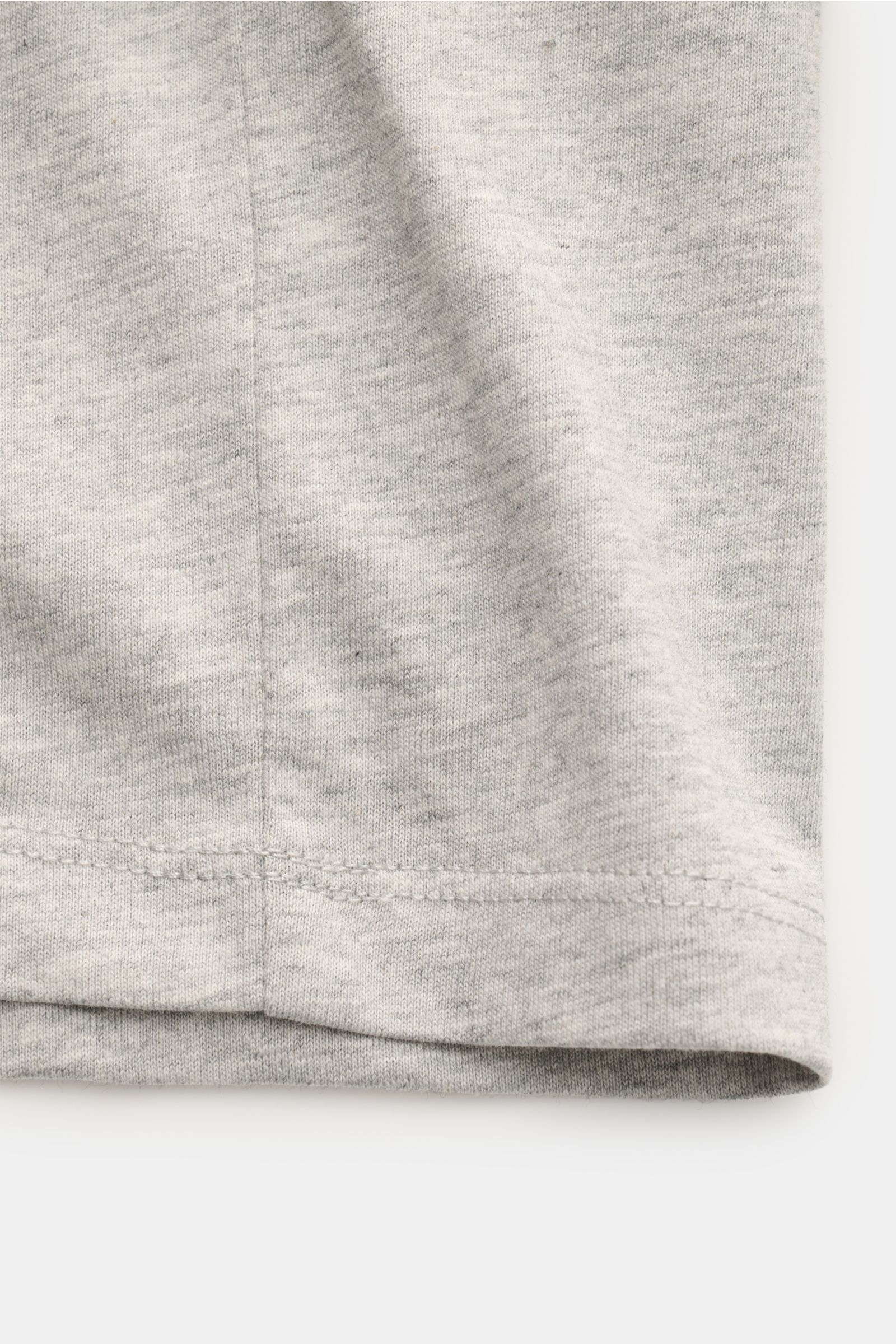 Ami Paris Rundhals-T-Shirt hellgrau aus weichem Jersey, Slim Fit, reine Baumwolle, Herz-Stitching auf Brust, Detailaufnahme vom Saum.