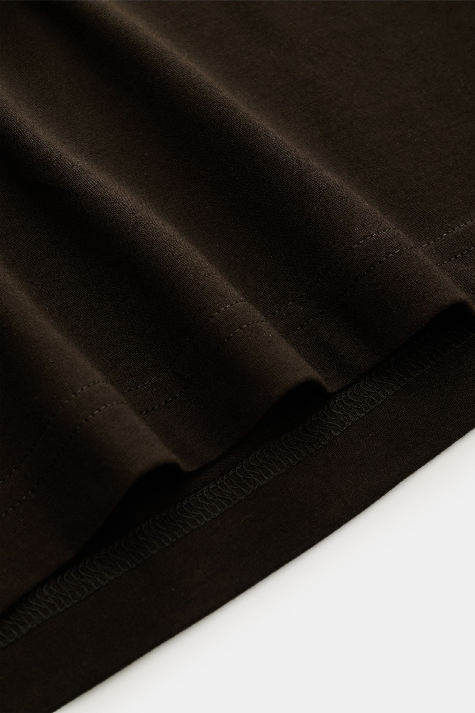 Nahaufnahme des Saums vom Stefan Brandt Rundhals-T-Shirt 'Enno' dunkelbraun aus weicher, formstabiler Bio-Pima-Baumwolle in Slim Fit.