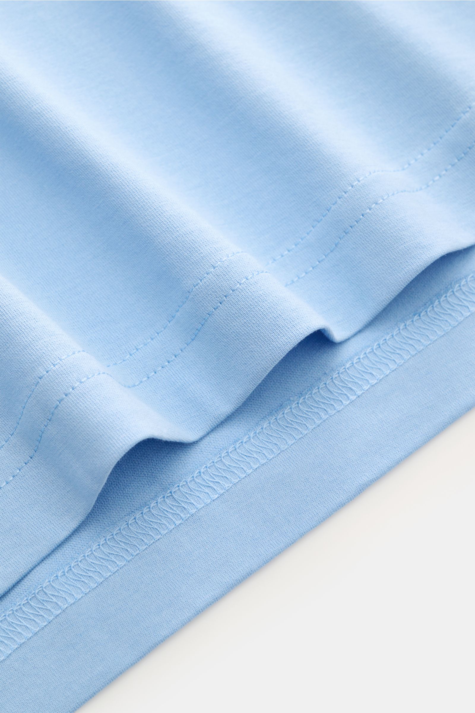 Nahaufnahme des Saums vom Stefan Brandt Rundhals-T-Shirt 'Enno' hellblau aus feiner, weicher Jersey-Qualität in Slim Fit.