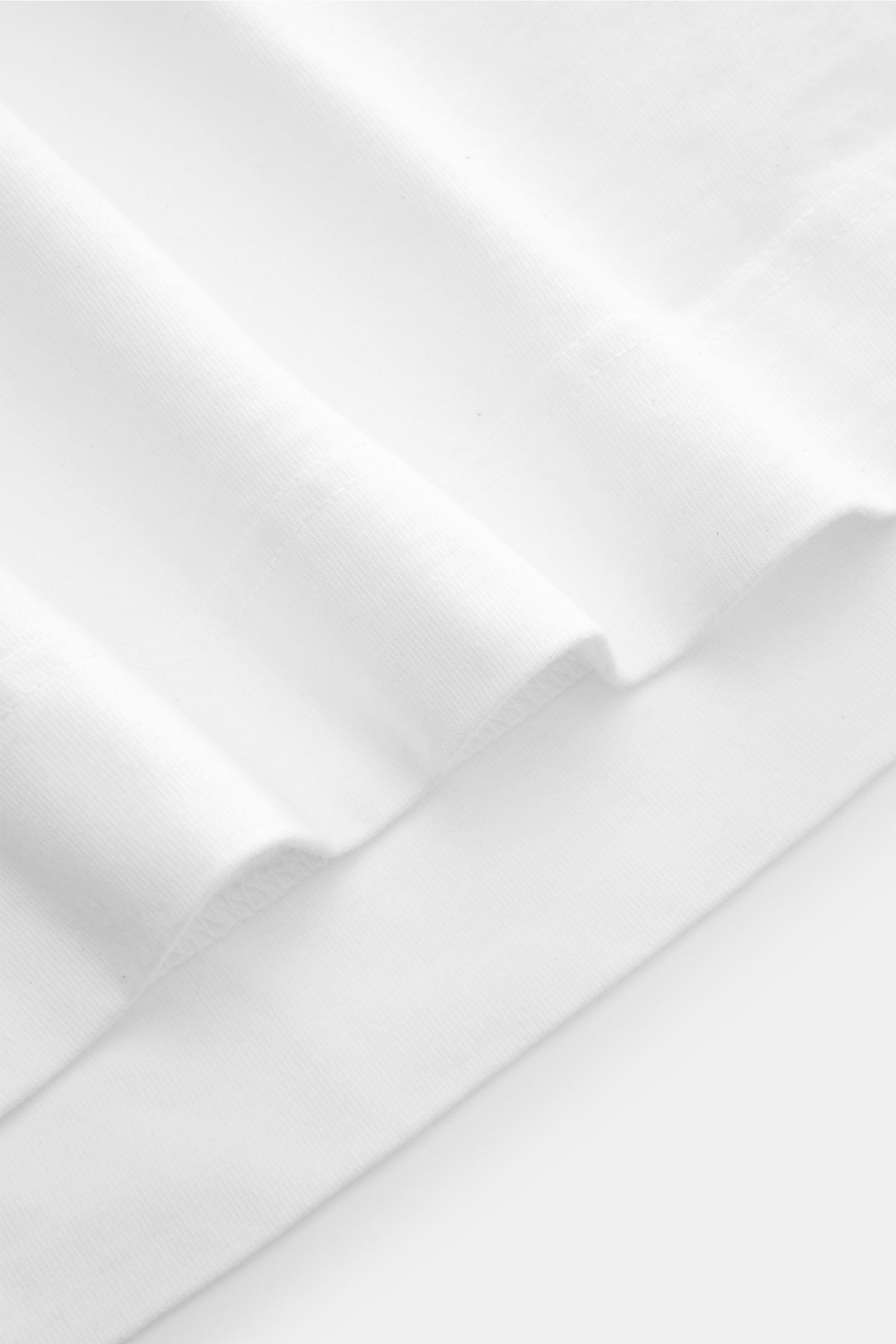 04651/ A trip in a bag Rundhals-T-Shirt 'Nunu Tee' weiß im Detail, Nahaufnahme der weißen Baumwoll-Jersey-Qualität und Saumnaht, weicher Griff, Oversized-Fit, Rundhalsausschnitt, Weblabel in Seitennaht. Tauchen Sie ein in den relaxten Lifestyle von 04651/
