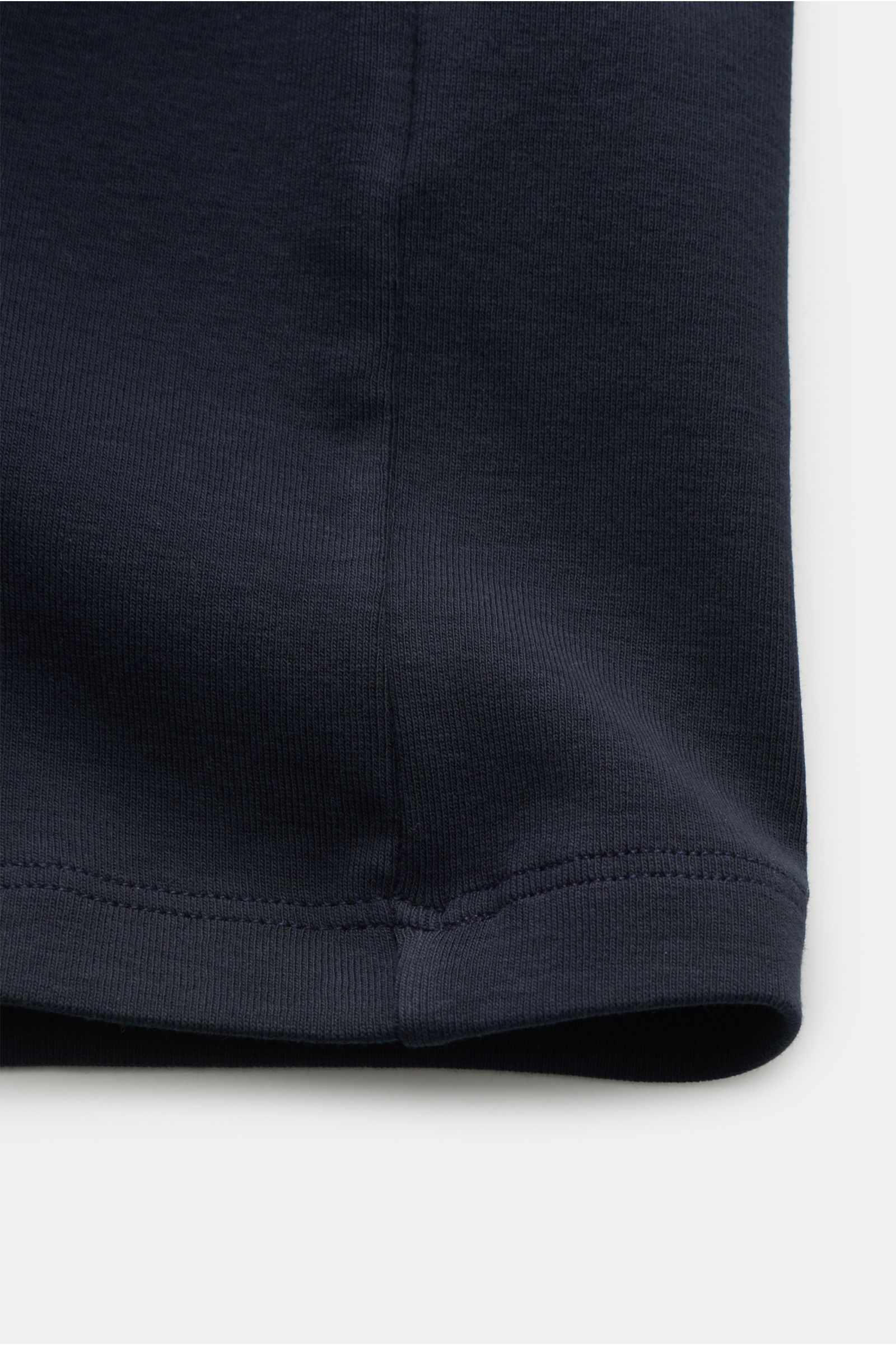 Close-up front view of the navy fabric hem of the Kiefermann Rundhals-T-Shirt 'Paddys' navy, made of pure cotton with a soft, slightly elastic slim fit and round neckline, emphasizing comfort and understated style. Das T-Shirt 'Paddys' von KIEFERMANN s