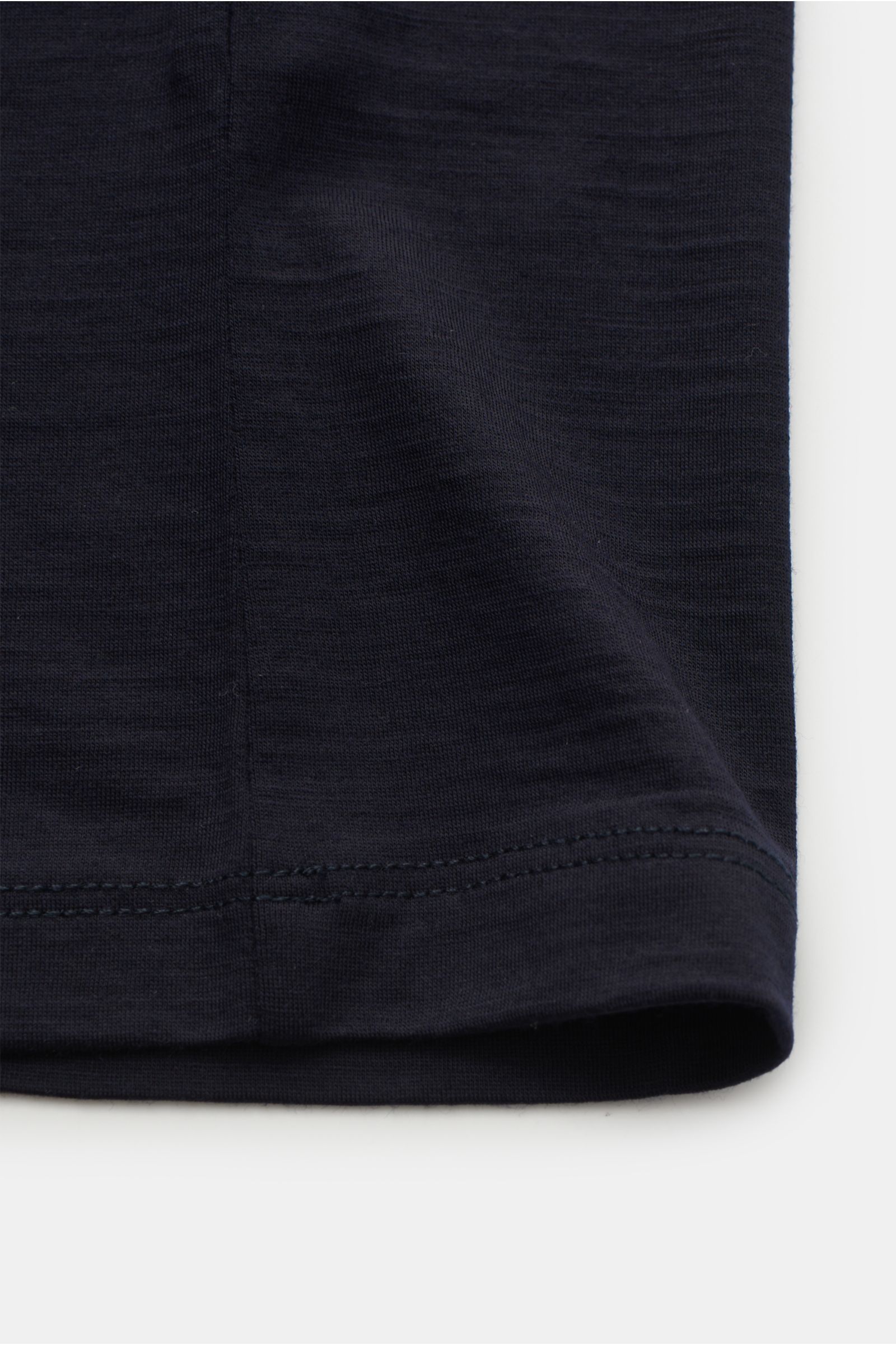 Close-up of the hem and side seam of The Product is the Hero Merino T-Shirt 'Wool Tee' navy, showing fine stitching and soft fabric texture from a flat lay perspective.

Description: THE PRODUCT IS THE HERO verleihen dem klassischen T-Shirt-Schnitt bei