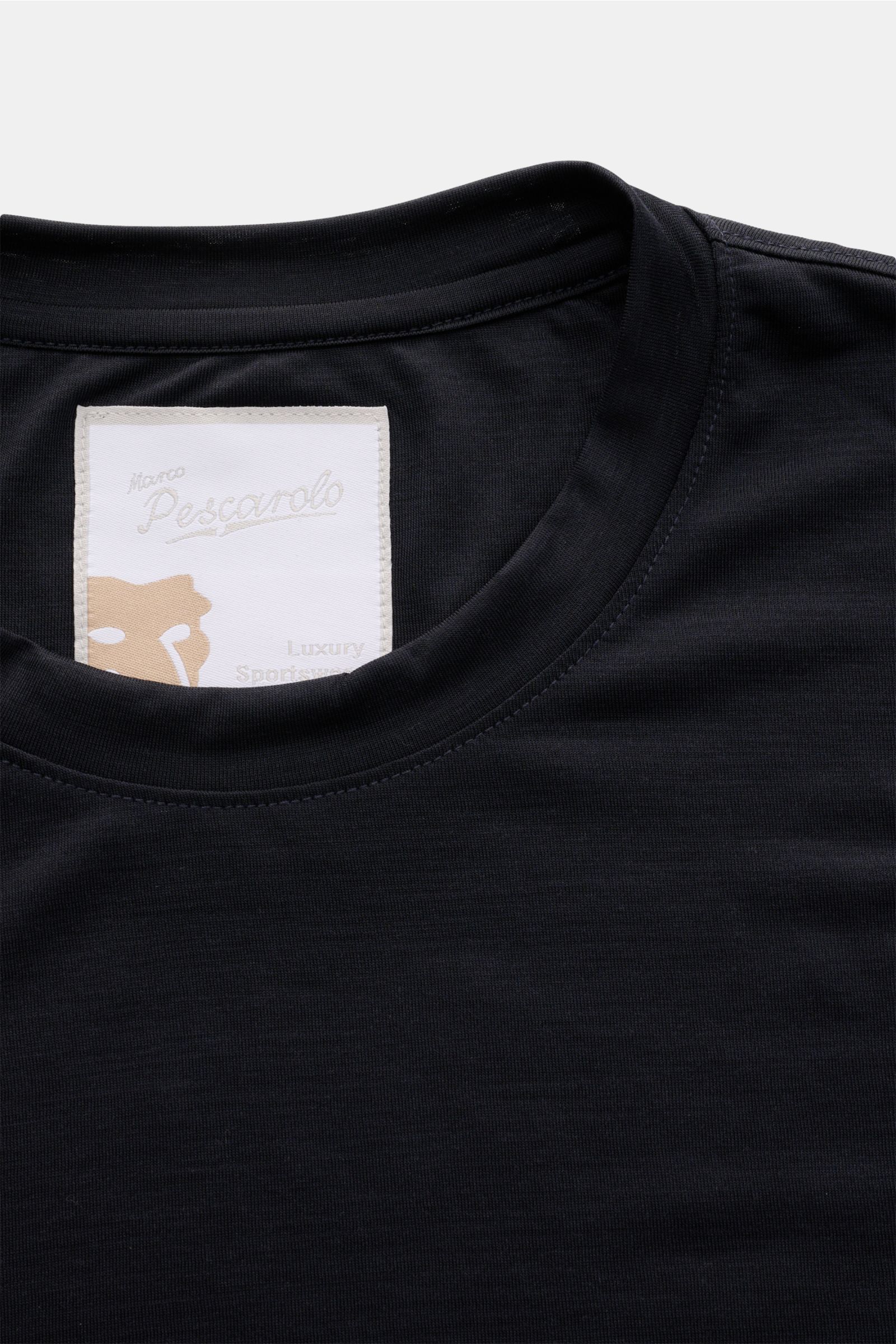 Close-up front view of the dark navy Marco Pescarolo Rundhals-T-Shirt 'James' showing the smooth round neckline and label. Für luxuriöse Woll-Verarbeitung steht MARCO PESCAROLO - so ist auch definitiv dieses T-Shirt ein edles Piece aus reiner, feinster