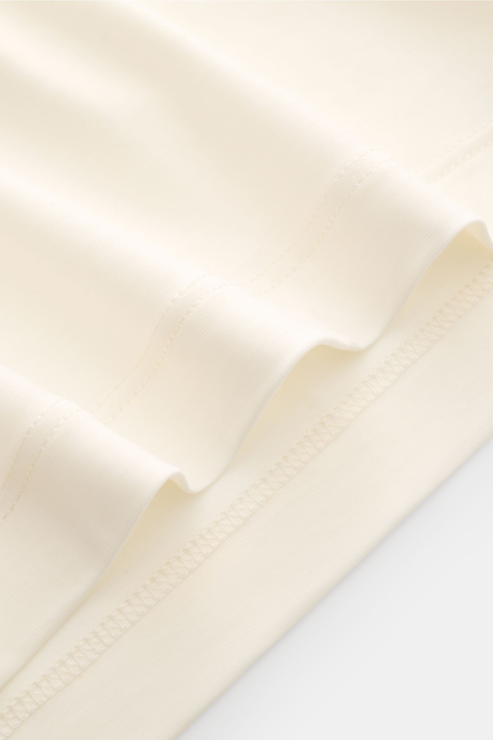 Close-up front view of the hem and stitching of Marco Pescarolo Rundhals-T-Shirt 'James' creme, made from smooth pure wool jersey, slim fit with short side slits.

Für luxuriöse Woll-Verarbeitung steht MARCO PESCAROLO - so ist auch definitiv dieses T-S