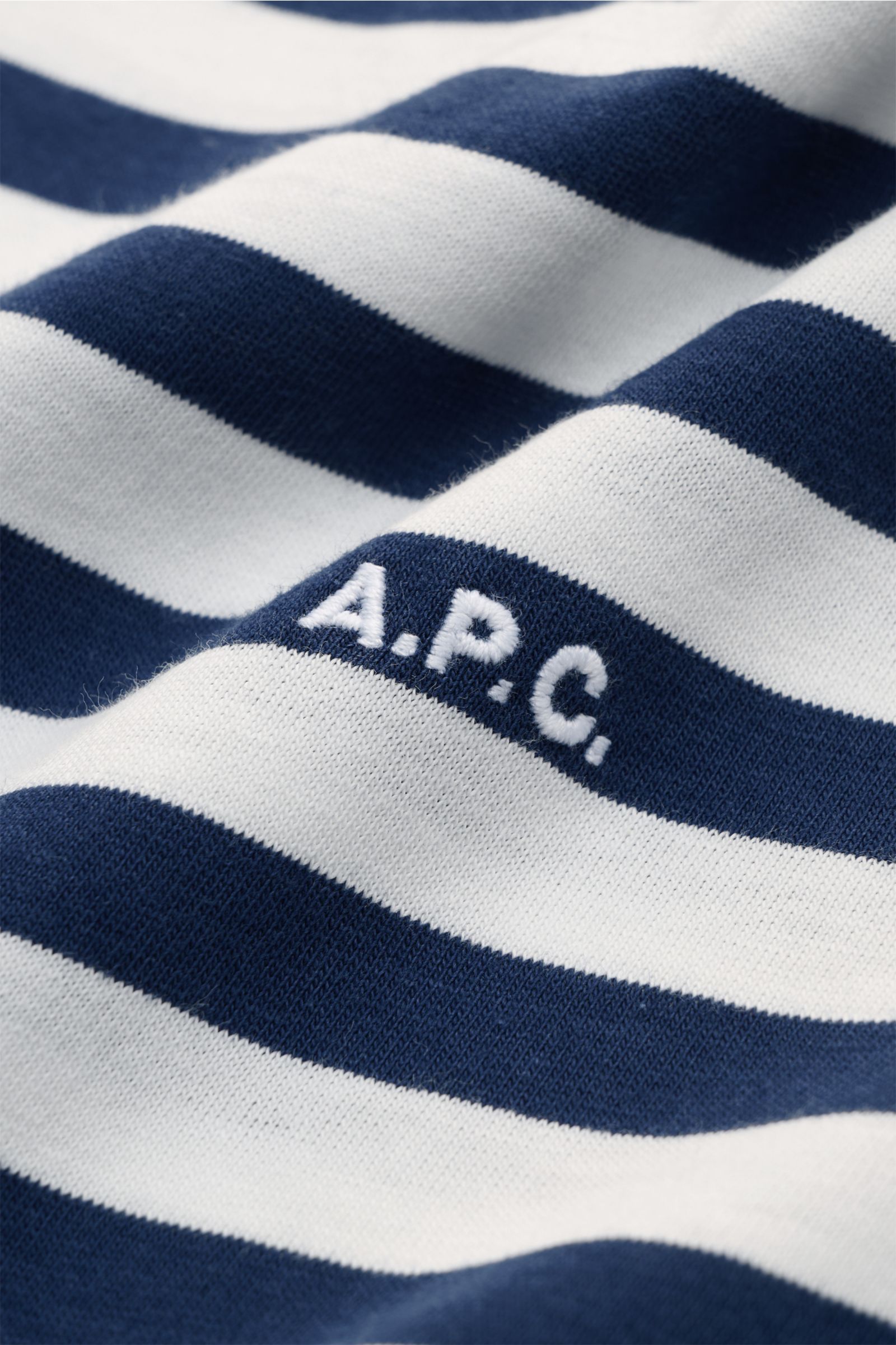 Close-up front detail of A.P.C. Rundhals-T-Shirt navy/offwhite gestreift showing navy and offwhite stripes and subtle embroidered logo.

Maritimer Look vom französischen Label A.P.C.: Dieses T-Shirt mit Rundhalsausschnitt aus reiner Baumwolle trägt ver