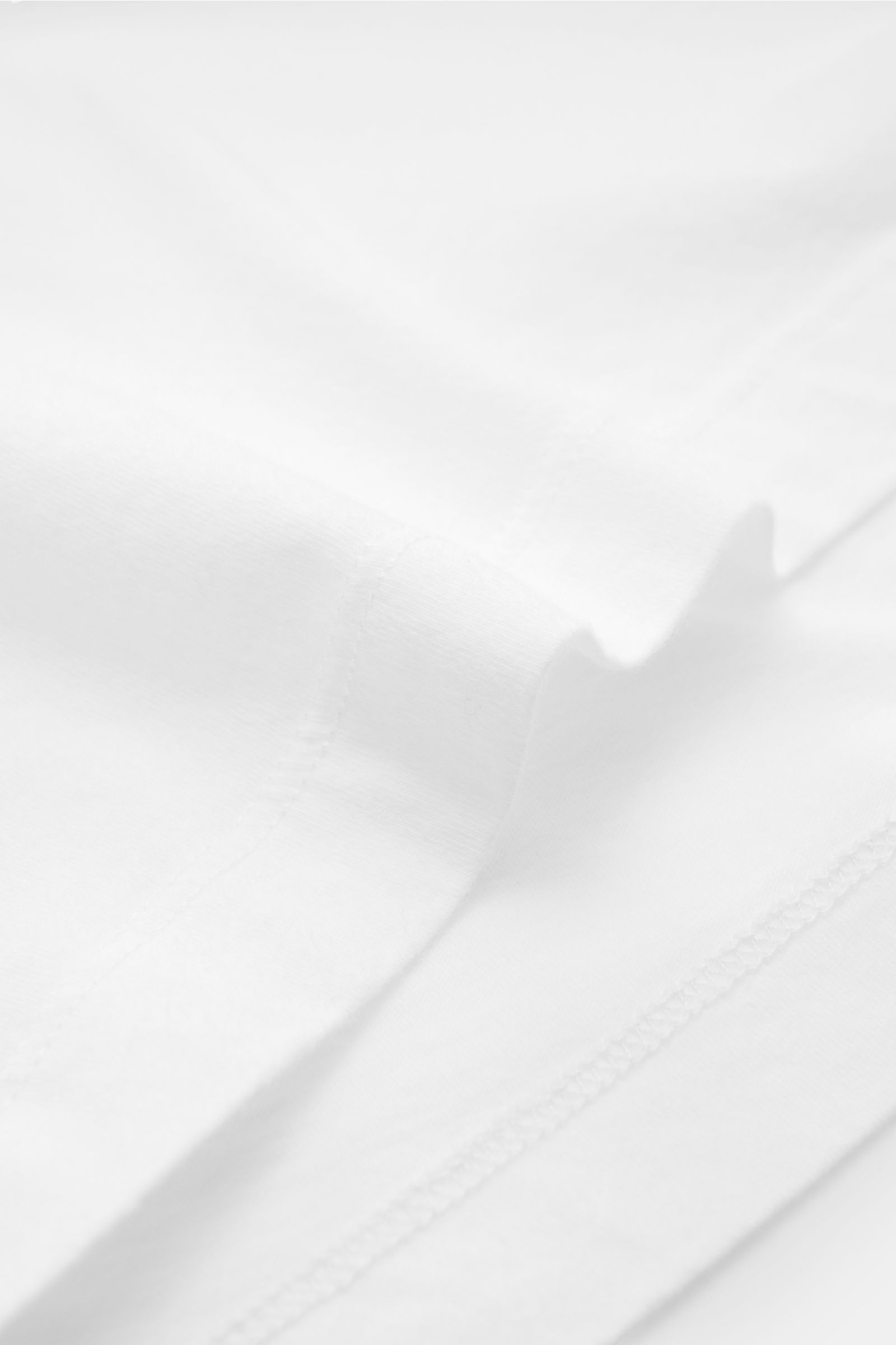 Nahaufnahme des weißen Officine Générale Rundhals-T-Shirts 'Cneck Tee' aus Bio-Baumwolle, Slim Fit, weicher Jersey, Rundhalsausschnitt.