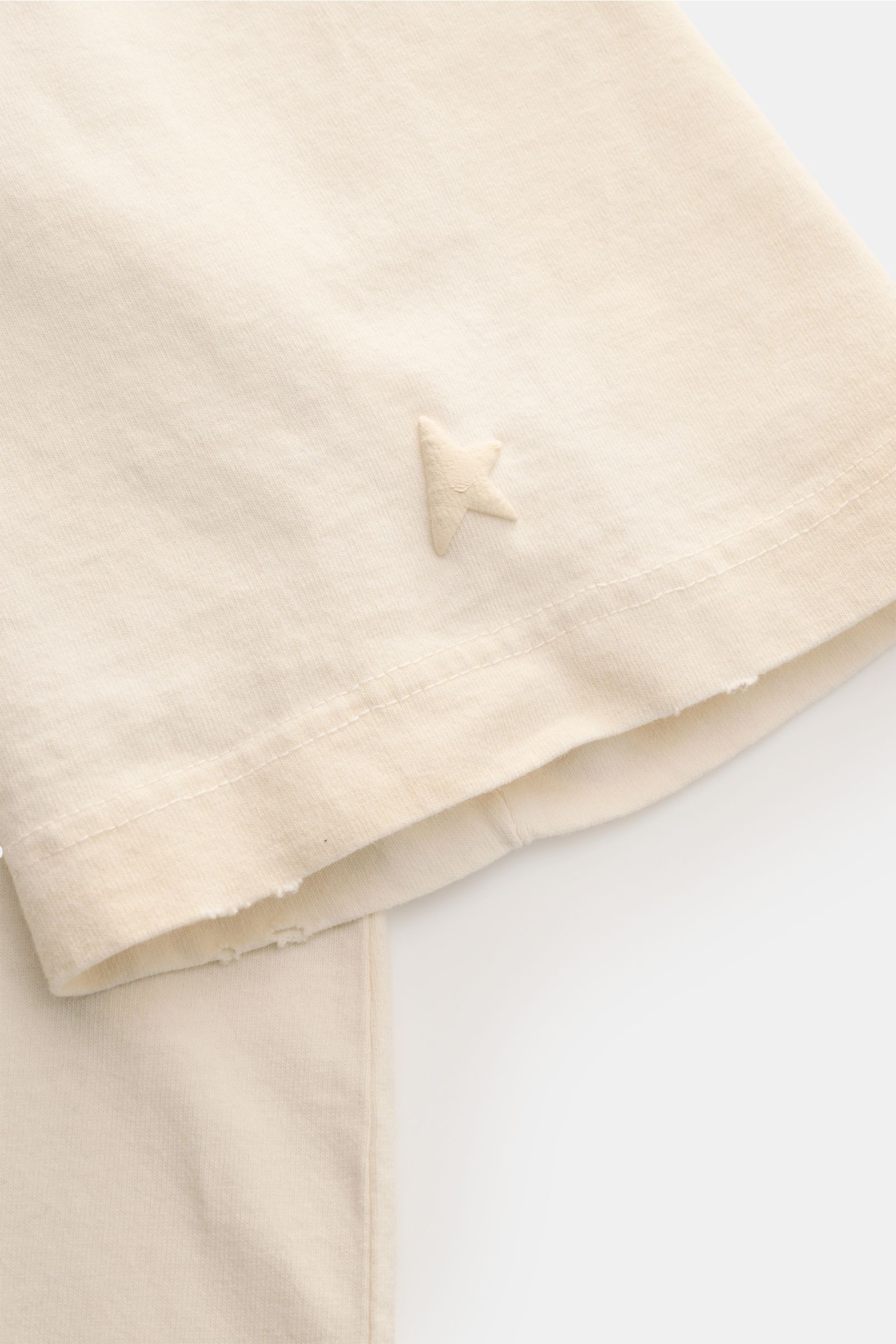 Golden Goose Rundhals-T-Shirt creme, Detailaufnahme des Ärmels mit Metall-Stern und Distressed-Details, Jersey aus Baumwolle.