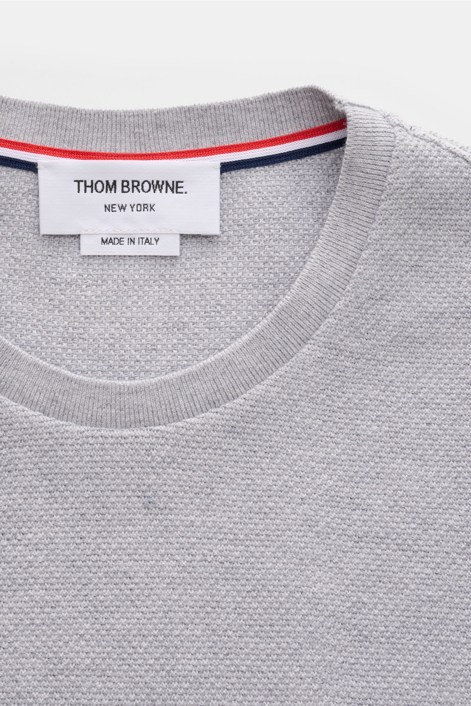 Nahaufnahme des Thom Browne Rundhals-T-Shirts grau meliert von oben, strukturiert aus reiner Baumwolle mit Tricolore-Streifen am Saum.