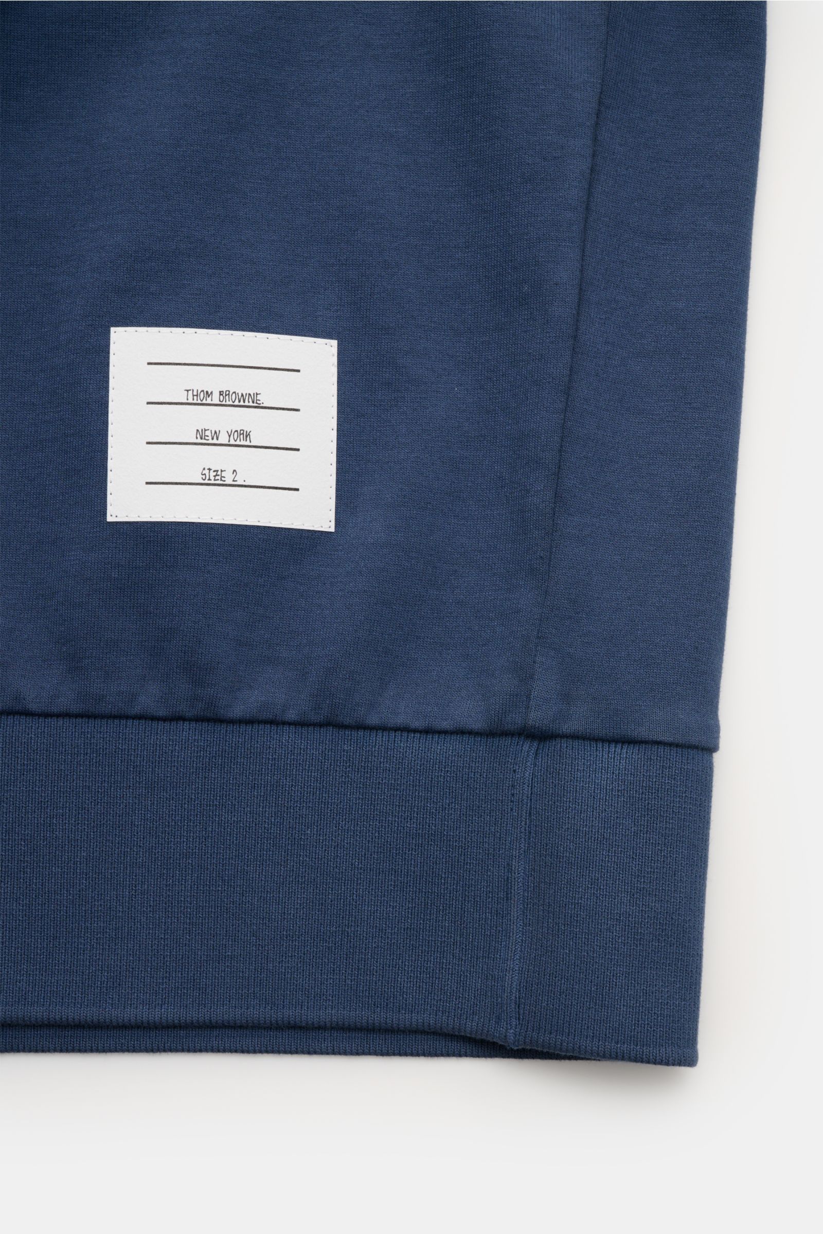 Detailaufnahme des Saums vom Thom Browne Rundhals-T-Shirt graublau aus schwerem Jersey, reine Baumwolle, mit breitem Saumbündchen und Markenlabel.

Beschreibung (aus dem Text integriert): Monochromes T-Shirt von THOM BROWNE aus schwerem Jersey aus reiner 