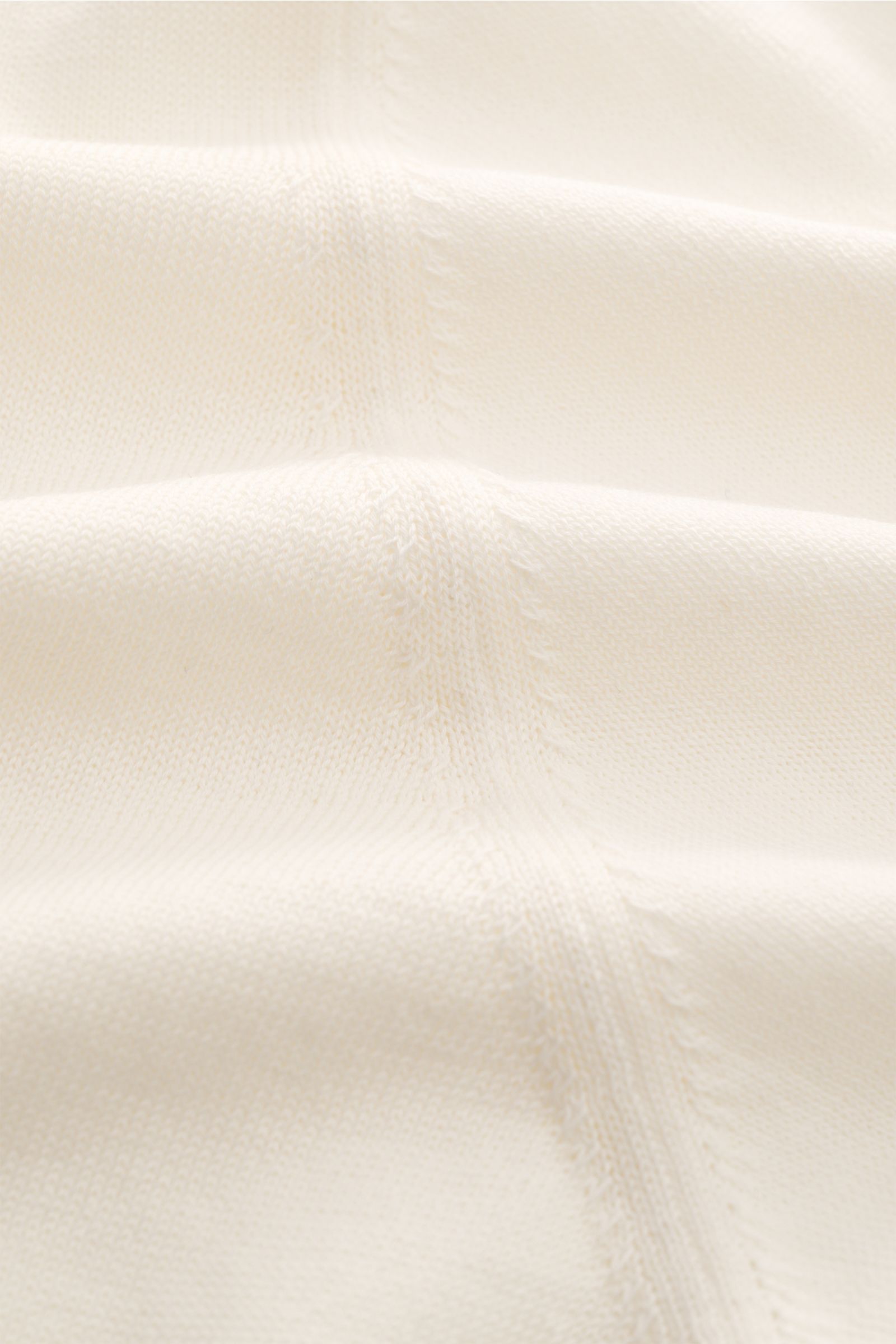 Nahaufnahme des Lardini Kurzarm-Rundhalspullover creme, fein gestrickt aus reiner Baumwolle mit weichem Griff und dezentem Logo.