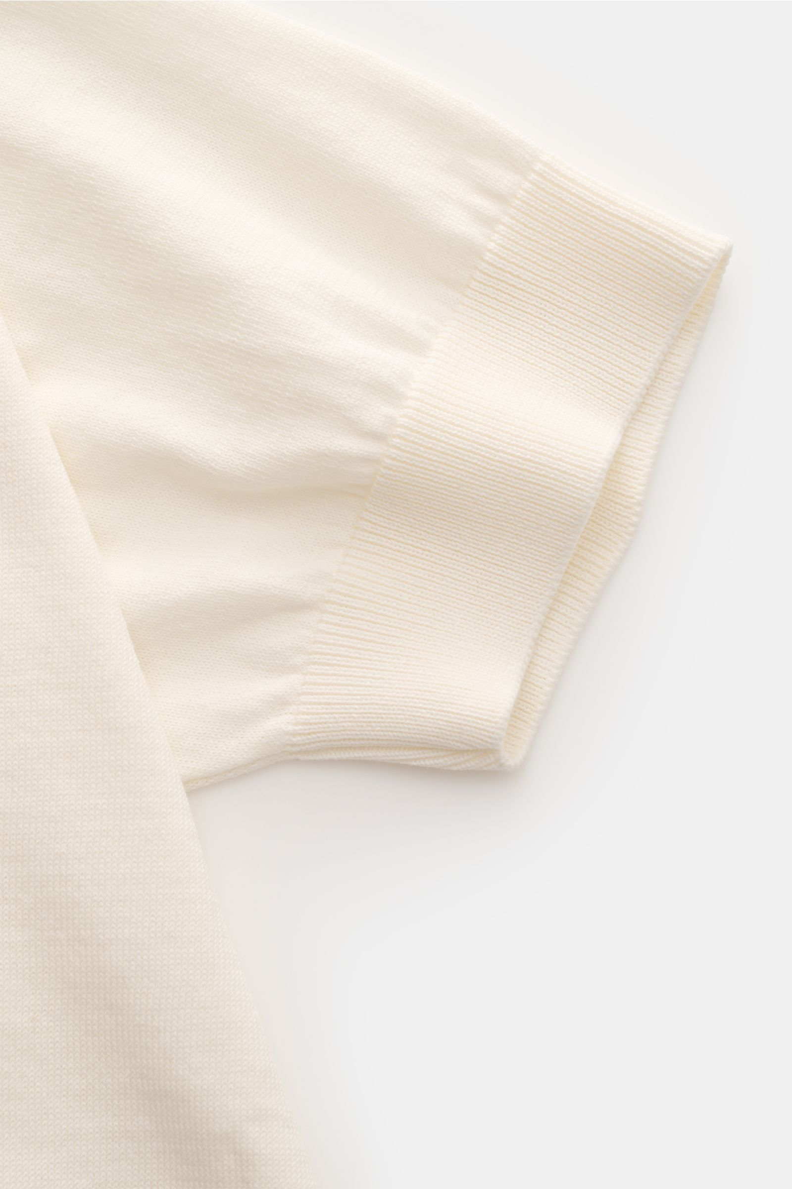 Nahaufnahme von Ärmel und Bund des Lardini Kurzarm-Rundhalspullover creme, fein gestrickt aus reiner Baumwolle mit weichem Griff.