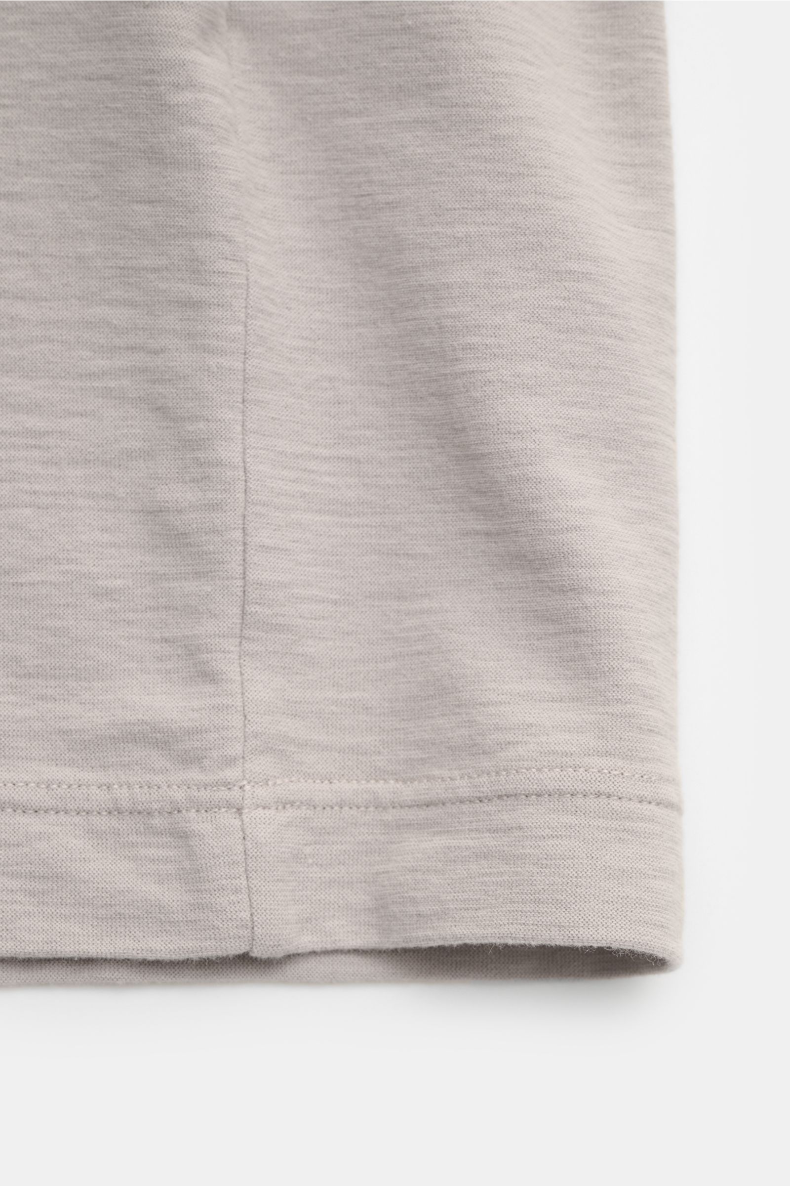 Nahaufnahme des Stone Island Rundhals-T-Shirts 'Ghost Piece' taupe, Slim Fit, aus elastischem Baumwolljersey mit tonalem Weblabel, aufgenommen von der Seitennaht unten.