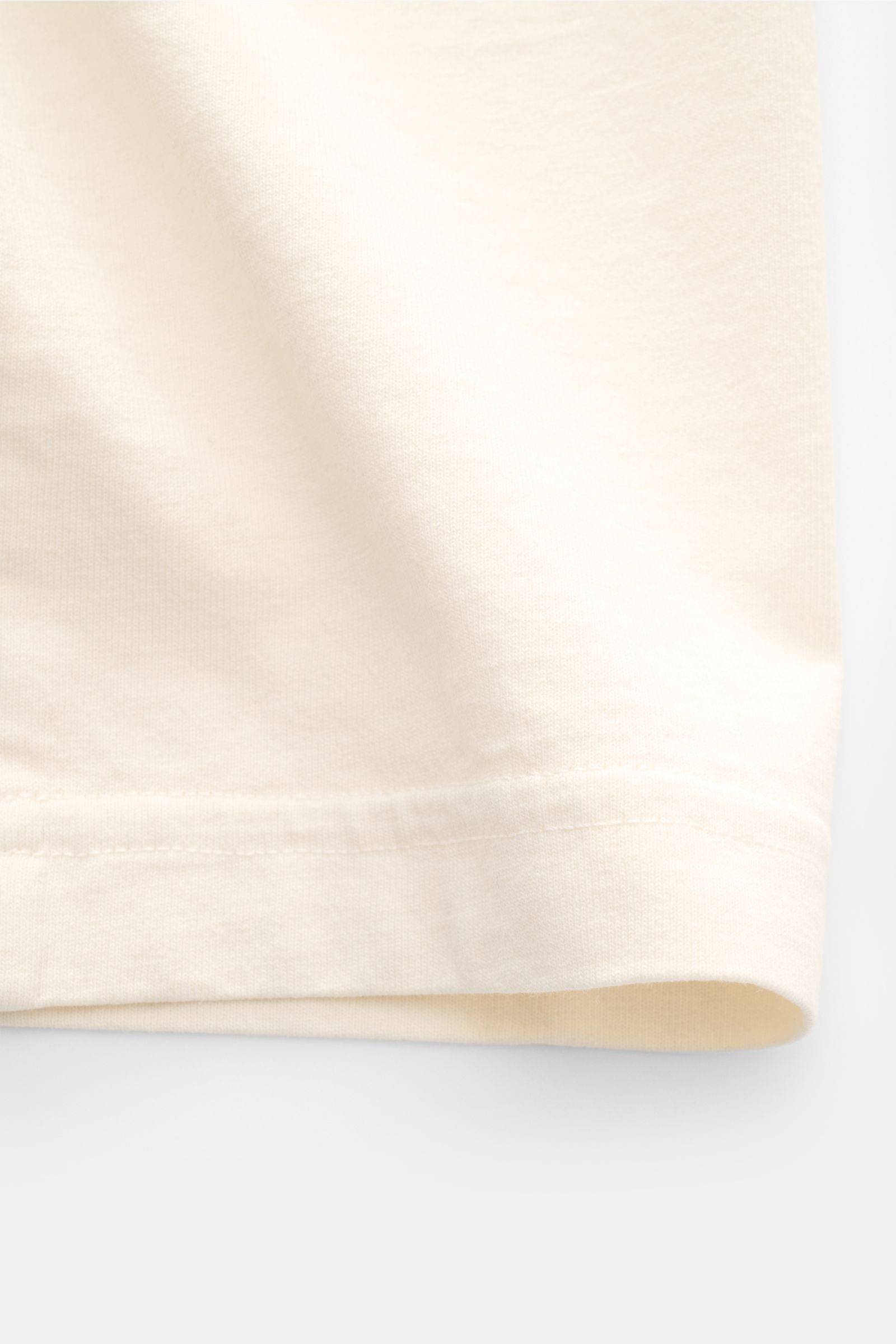 Stone Island Rundhals-T-Shirt 'Marina' creme shown in a close-up side view, highlighting soft, heavy cotton fabric and hem details. Legeres Urlaubs-Essential: Das T-Shirt aus der STONE ISLAND 'Marina' Capsule Collection steht für lässige Looks mit mari