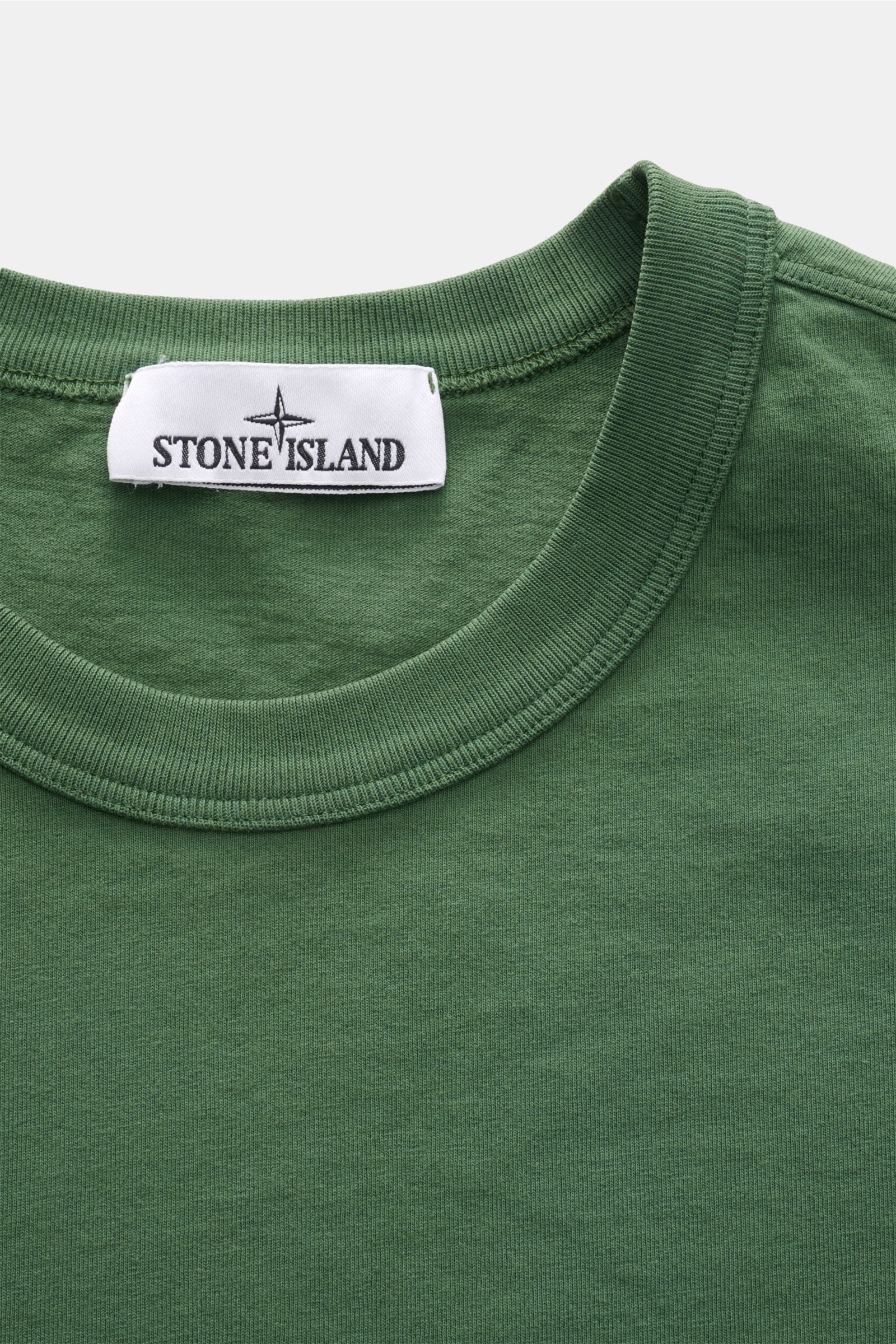 Stone Island Rundhals-T-Shirt 'Marina' grün shown in close-up from above, highlighting the ribbed round neckline and label.

Legeres Urlaubs-Essential: Das T-Shirt aus der STONE ISLAND 'Marina' Capsule Collection steht für lässige Looks mit maritimer N