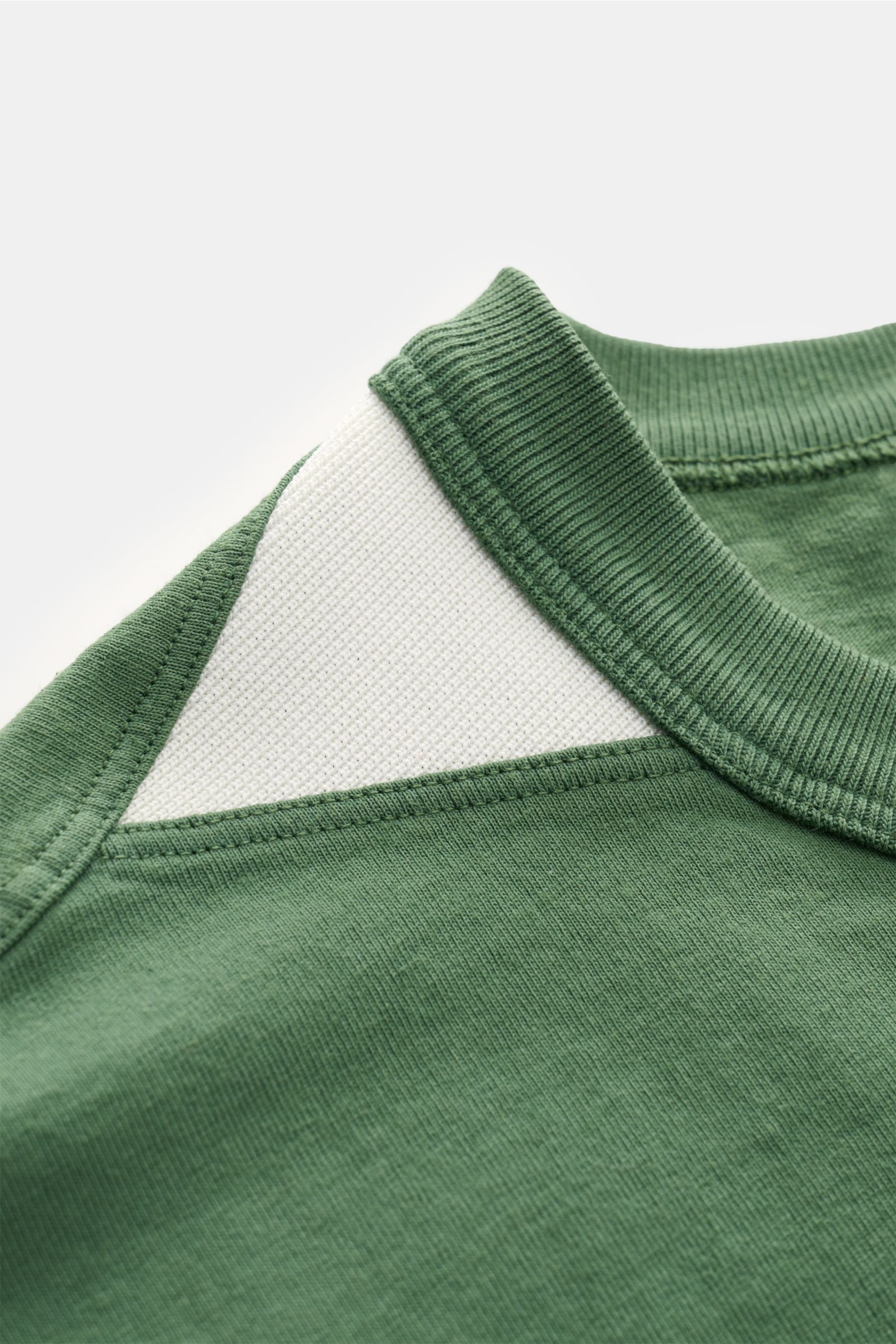 Close-up of the shoulder and neckline from the top side, showing the green Stone Island Rundhals-T-Shirt 'Marina' grün with white ribbed detail.

Legeres Urlaubs-Essential: Das T-Shirt aus der STONE ISLAND 'Marina' Capsule Collection steht für lässige 