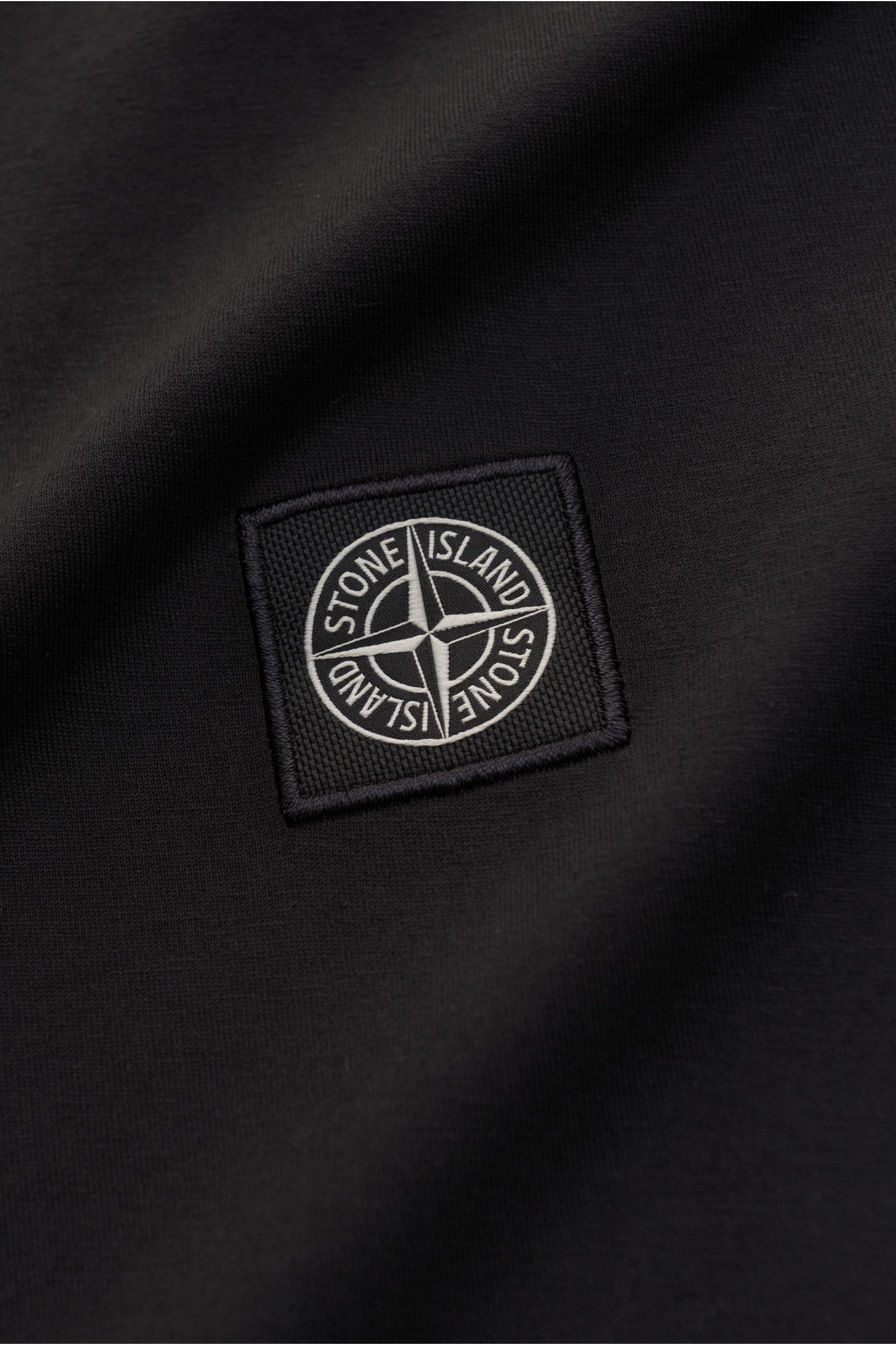 Stone Island T-Shirt 'Basic Cotton' schwarz mit Weblabel auf der Brust, reine Baumwolle, weicher Griff, Slim Fit, Rundhalsausschnitt, Detailaufnahme.