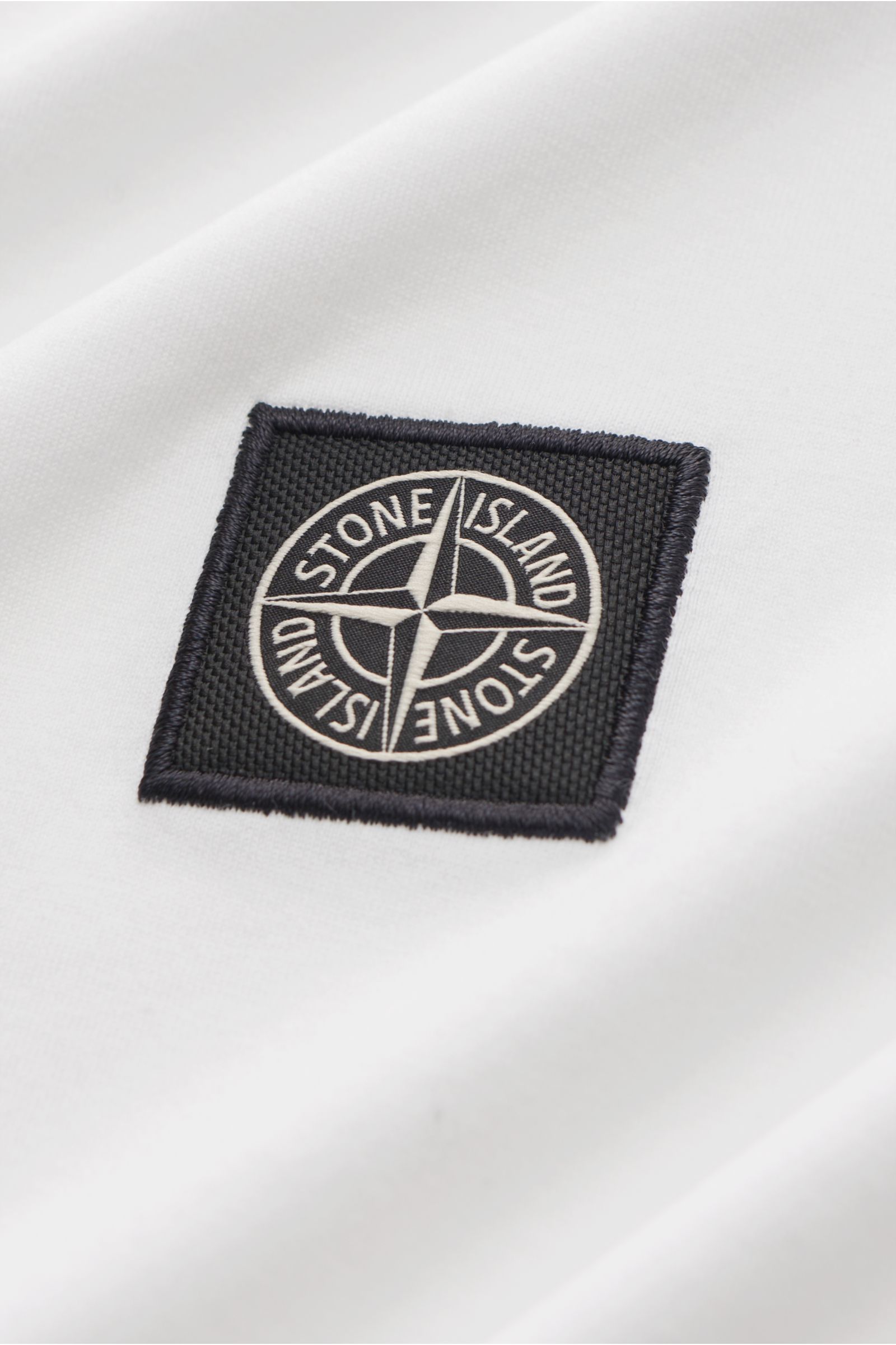 Stone Island T-Shirt 'Basic Cotton' weiß, Nahaufnahme seitlich auf Weblabel auf der Brust, reine Baumwolle, Slim Fit, Rundhalsausschnitt, weicher Griff.