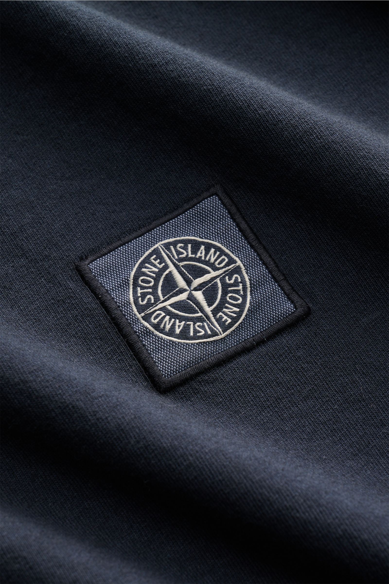 Nahaufnahme des Weblabels auf der Brust des Stone Island T-Shirts 'Dyed Regular Fit' navy aus reiner Baumwolle mit weichem Griff.