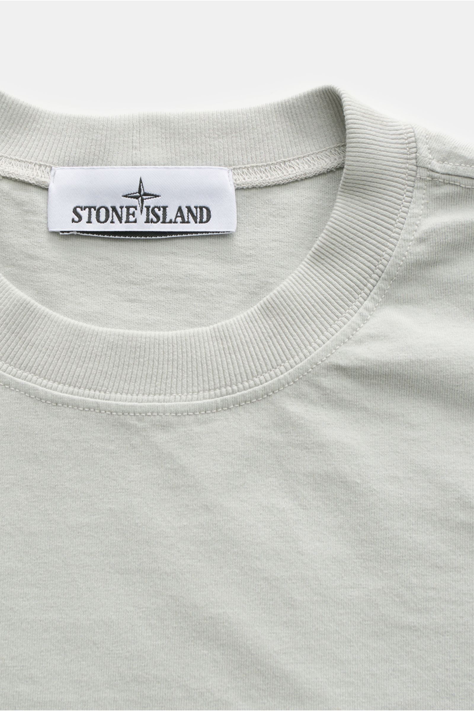 Close-up front view of Stone Island Rundhals-T-Shirt hellgrau showing light grey garment-dyed cotton with ribbed round neckline and STONE ISLAND label.

STONE ISLAND liefert mit diesem legeren T-Shirt aus Garment-dyed-Baumwolle mit charakteristischem K