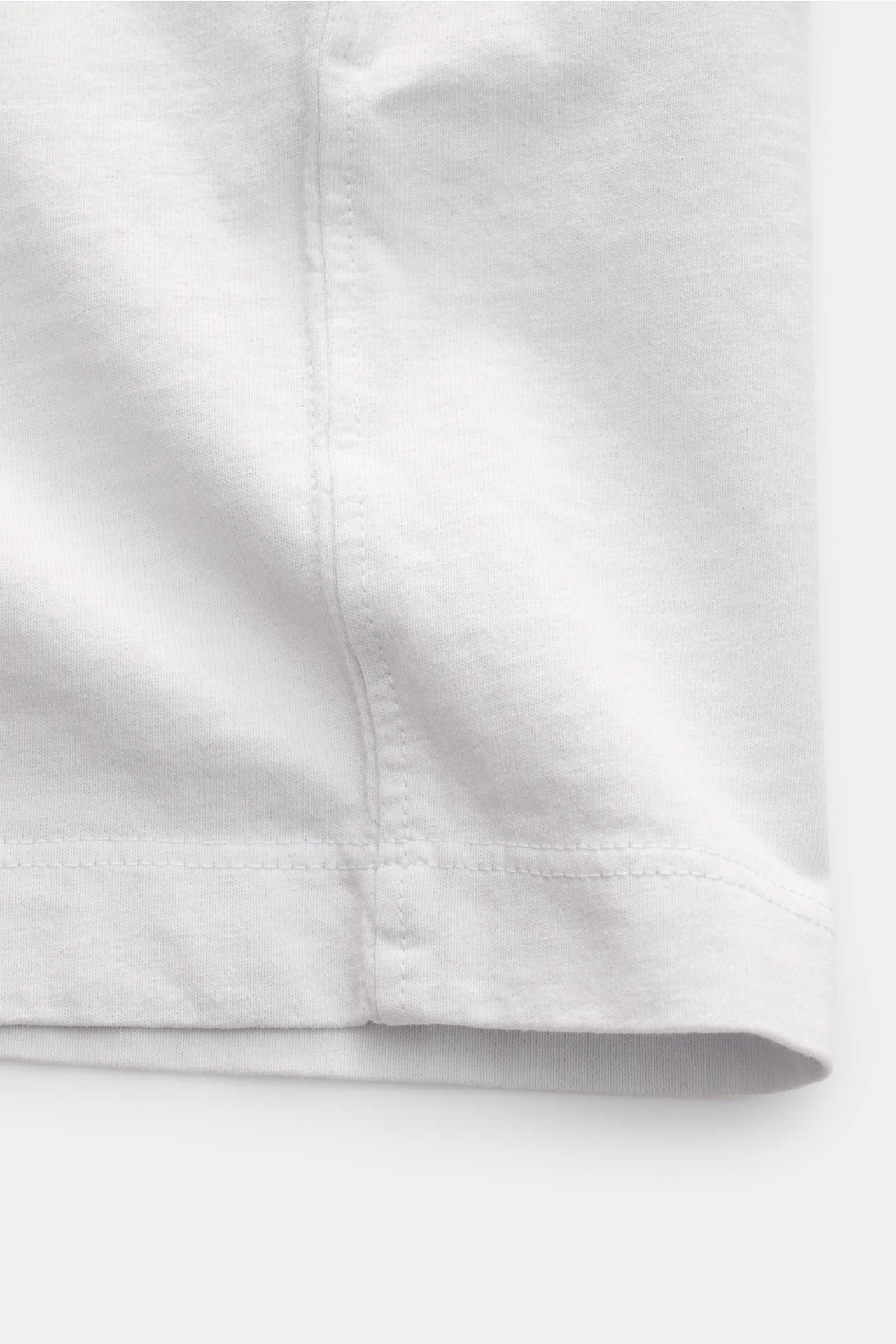 Stone Island T-Shirt 'Dyed Regular Fit' hellgrau aus reiner Bio-Baumwolle, weicher Griff, Rundhalsausschnitt, Weblabel auf der Brust, Detailansicht Saum und Naht.