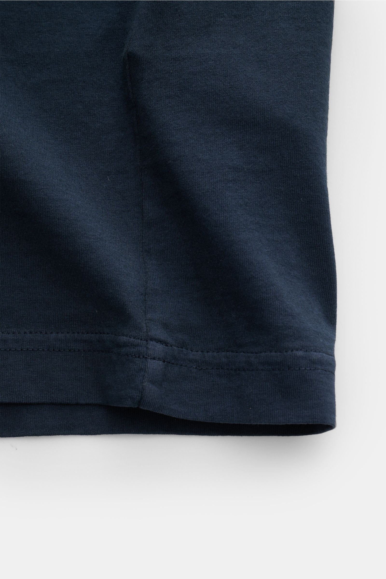 Close-up of the hem of the Stone Island T-Shirt 'Print' navy, showing fabric texture and stitching from a front angle.

Description:  
Eyecatcher mit Print: Das T-Shirt von STONE ISLAND aus reiner Bio-Baumwolle rundet legere Freizeitlooks mühelos ab un