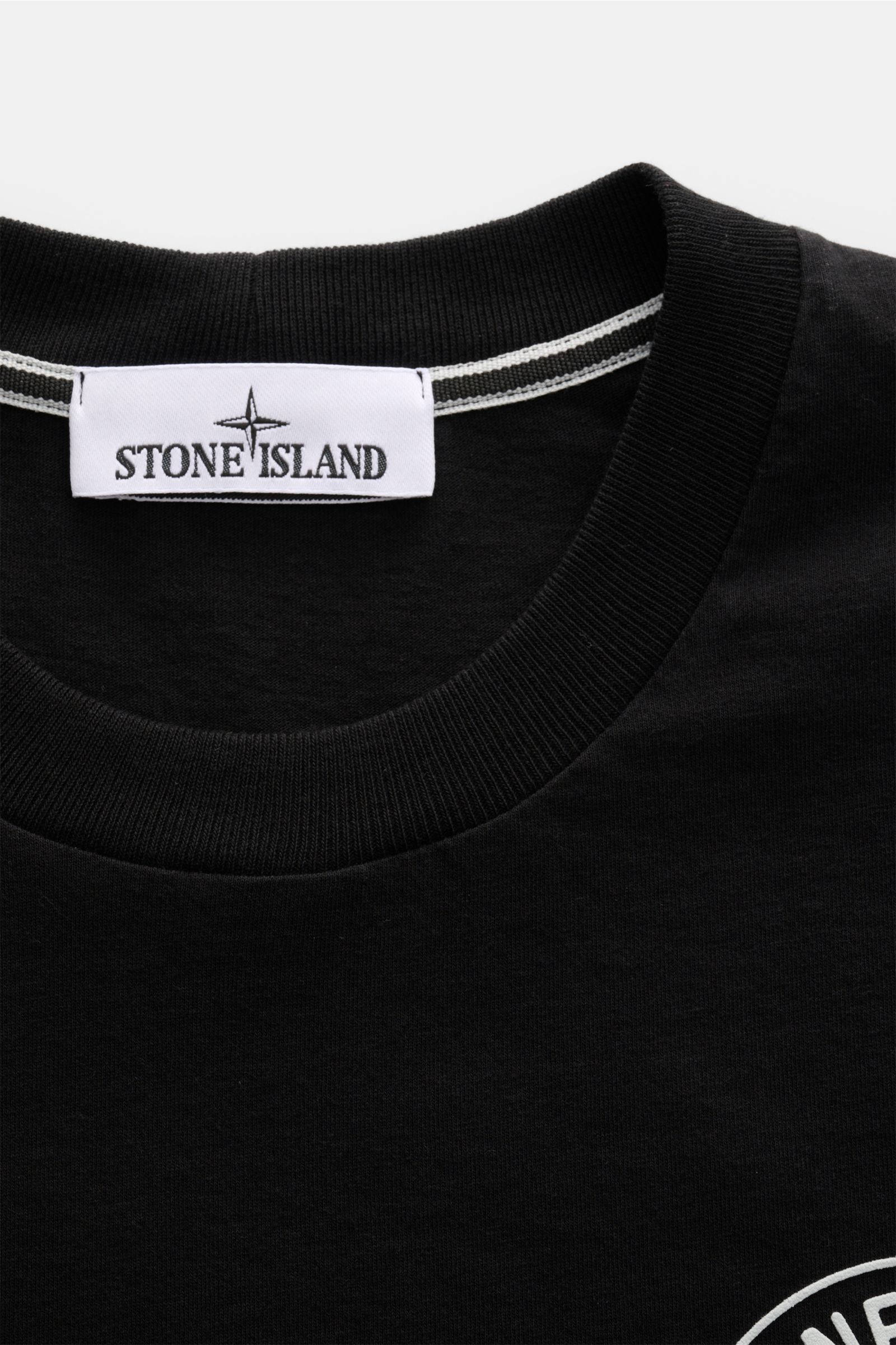 Stone Island T-Shirt 'Print' schwarz, Nahaufnahme des Rundhalsausschnitts aus reiner Baumwolle, weicher Griff, Regular Fit, Logo-Print sichtbar.