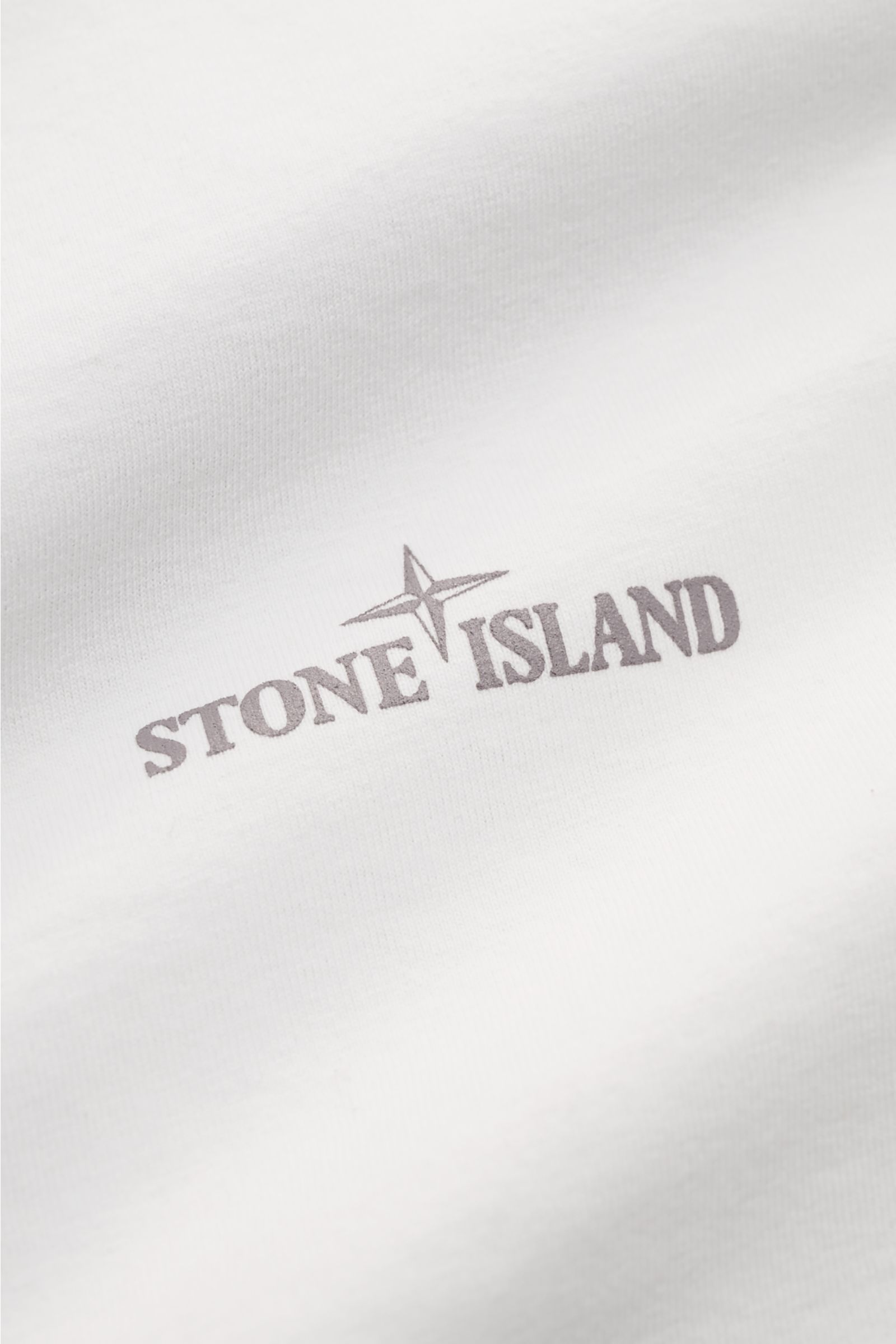 Stone Island Rundhals-T-Shirt offwhite aus schwerer Baumwolle, Front mit STONE ISLAND-Print, Detailaufnahme der Stoffstruktur und Frontprint.