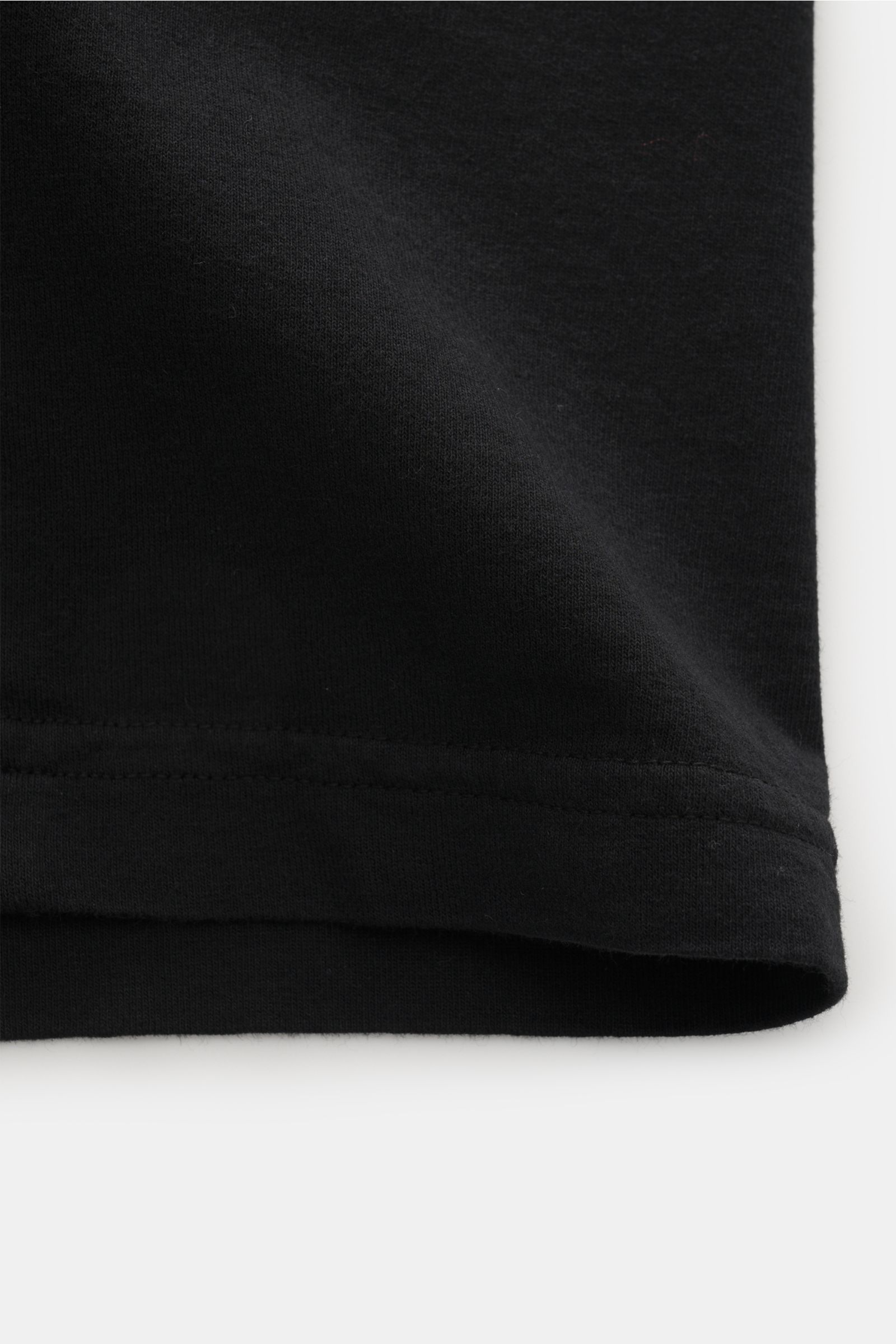 Stone Island Rundhals-T-Shirt schwarz, Detailaufnahme vom unteren Saum aus leichter Seitenperspektive, Baumwolle, weicher Griff, Regular Fit, Front- und Rückenprint sichtbar.