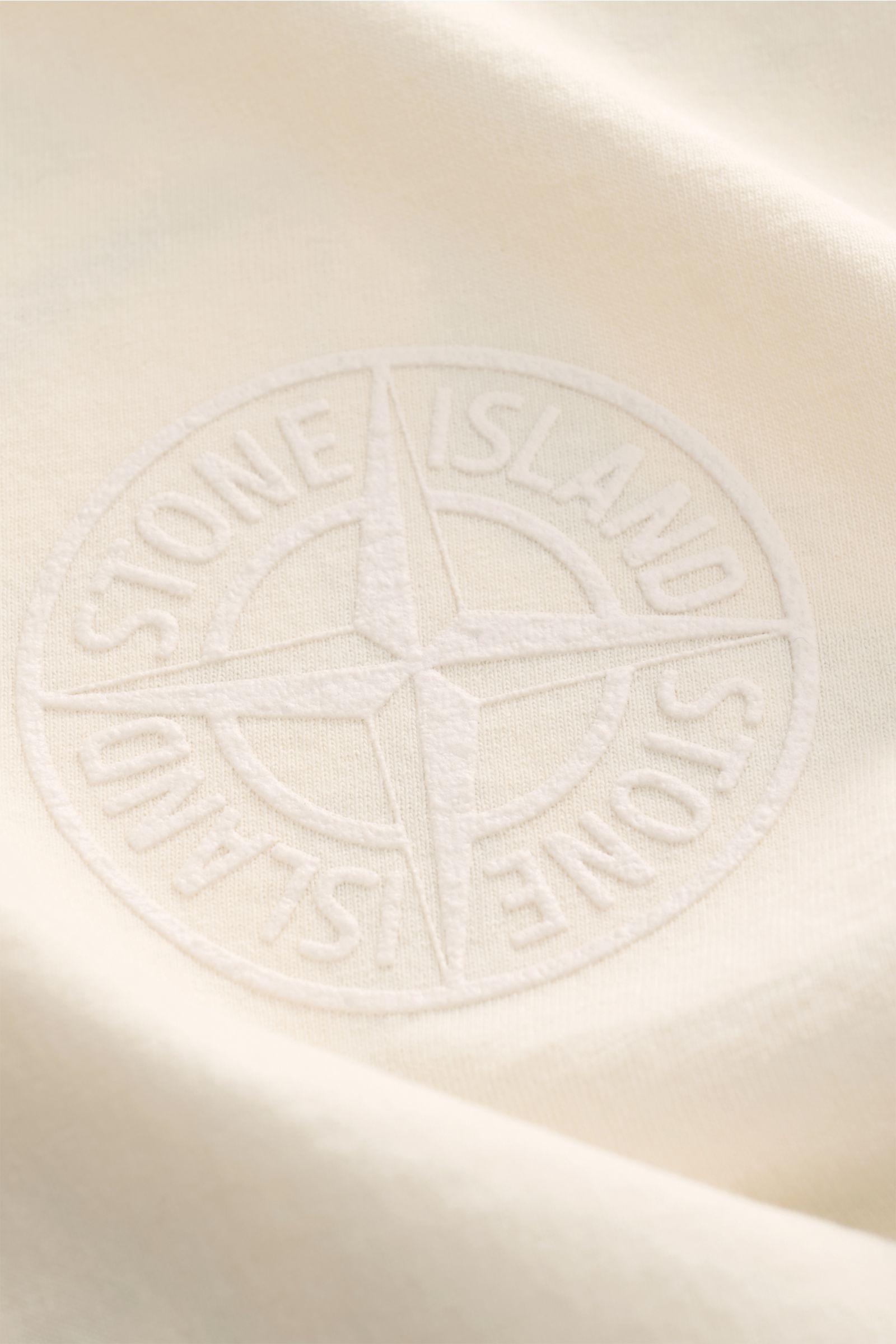 Close-up front view of Stone Island Crew neck T-shirt cream showing embossed STONE ISLAND logo on heavyweight cotton fabric.

Striking casual basic: STONE ISLAND presents this casual T-shirt made from heavyweight cotton fabric with a striking back prin