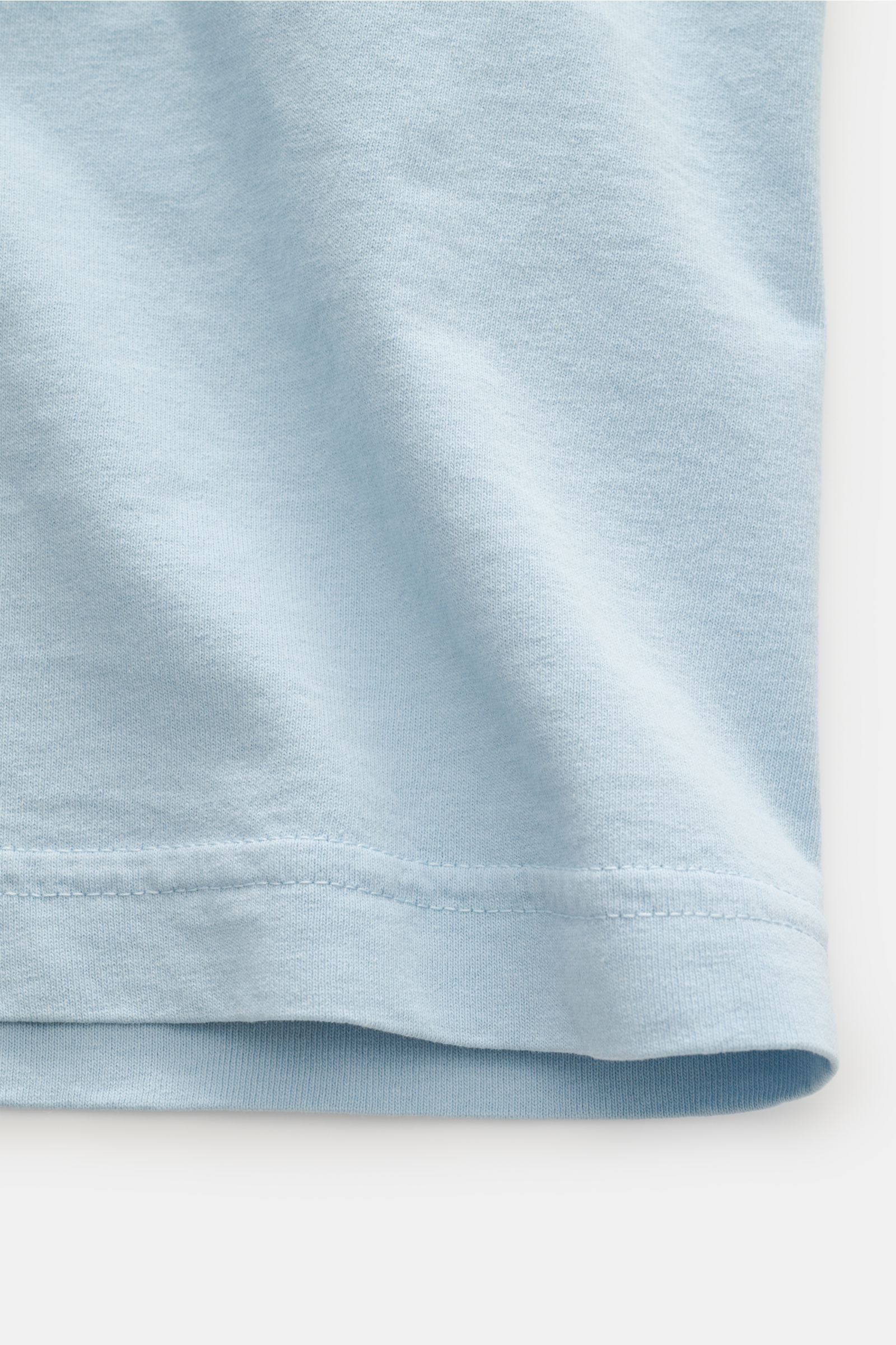 Stone Island Rundhals-T-Shirt hellblau, Detailfoto des unteren Saums aus Jersey-Baumwolle mit weichem Griff, Regular Fit, Rückenprint nicht sichtbar.