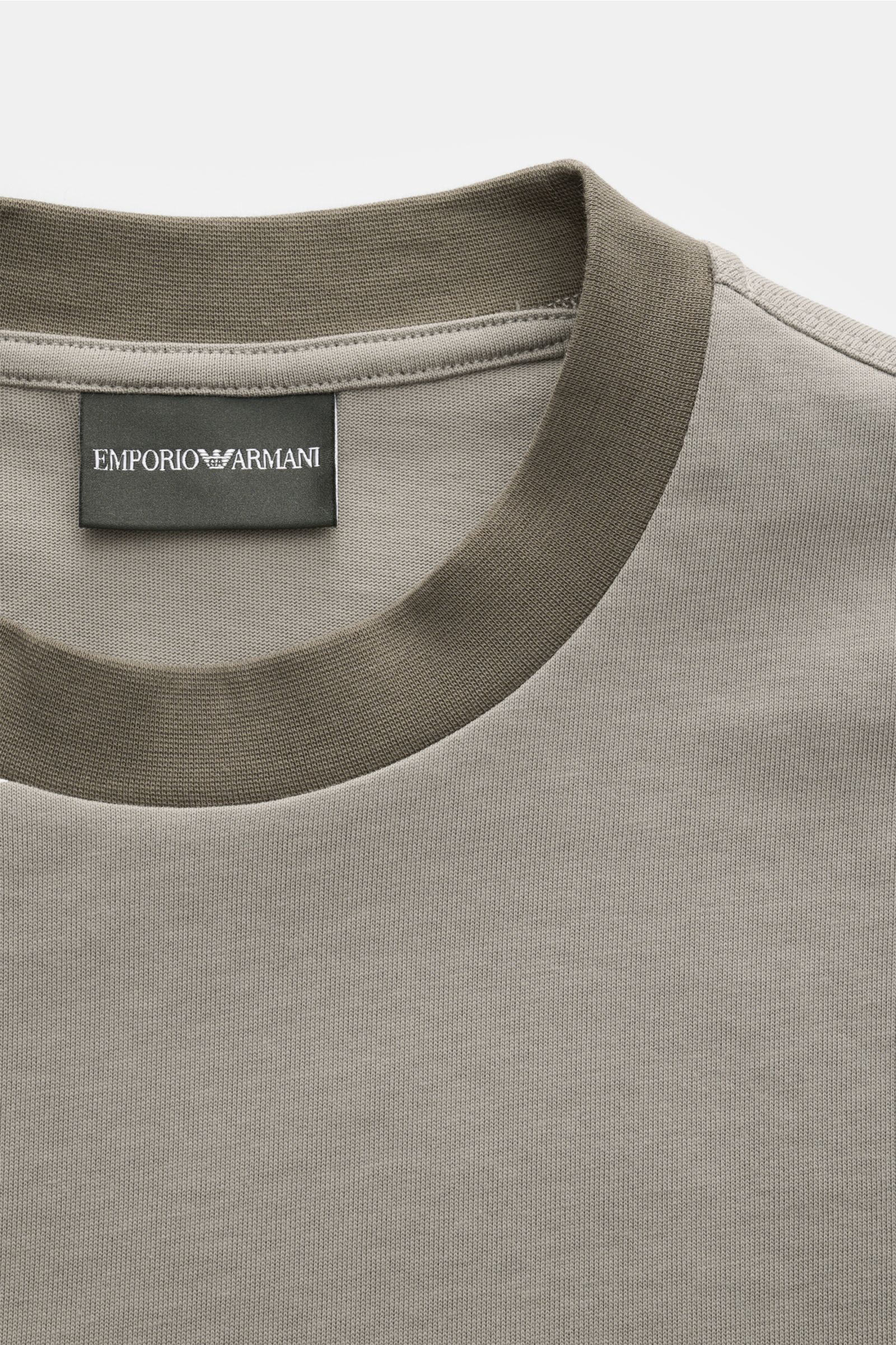 Emporio Armani Rundhals-T-Shirt taupe, Detailaufnahme des kontrastfarbenen Rundhalsausschnitts und Labels, Jersey-Baumwolle, Regular Fit, gummiertes Frontlogo, Y2K-Stitching hinten.