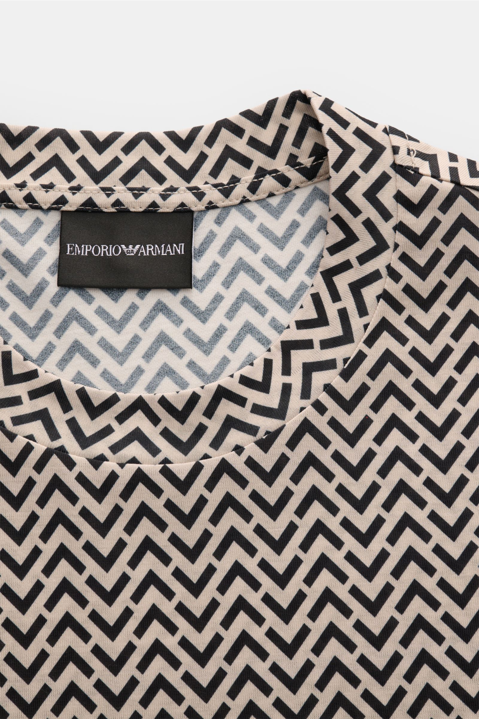 Nahaufnahme des Emporio Armani Rundhals-T-Shirt schwarz/sand gemustert mit retroeskem Muster, Rundhalsausschnitt und Logo-Stitching am Saum, fotografiert von oben, Jersey aus Lyocell und Baumwolle, Slim Fit, glatter Griff.