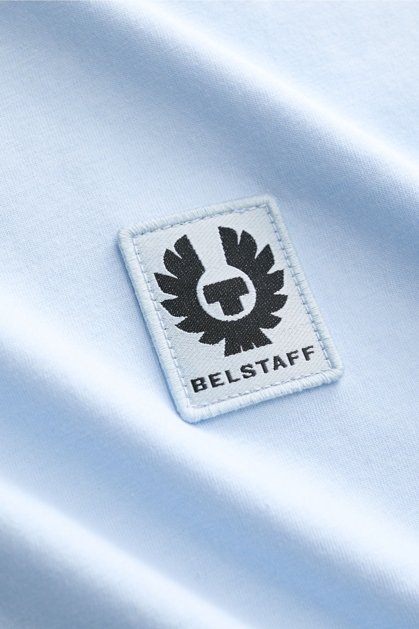 Nahaufnahme des hellblauen Belstaff Rundhals-T-Shirts aus weichem Baumwoll-Jersey mit Slim Fit und dezentem BELSTAFF-Weblabel.