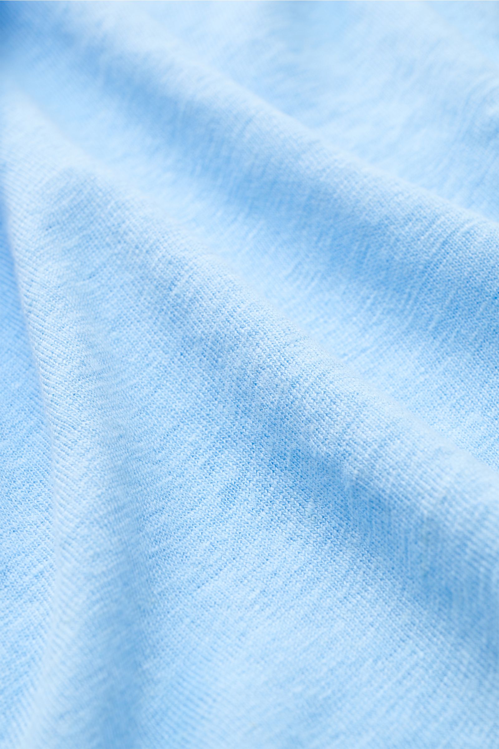 Nahaufnahme der hellblauen Jersey-Leinenstruktur mit leicht griffiger Haptik, luftiger Qualität und leichtem Stretch vom 04651/ A trip in a bag Leinen-T-Shirt hellblau.