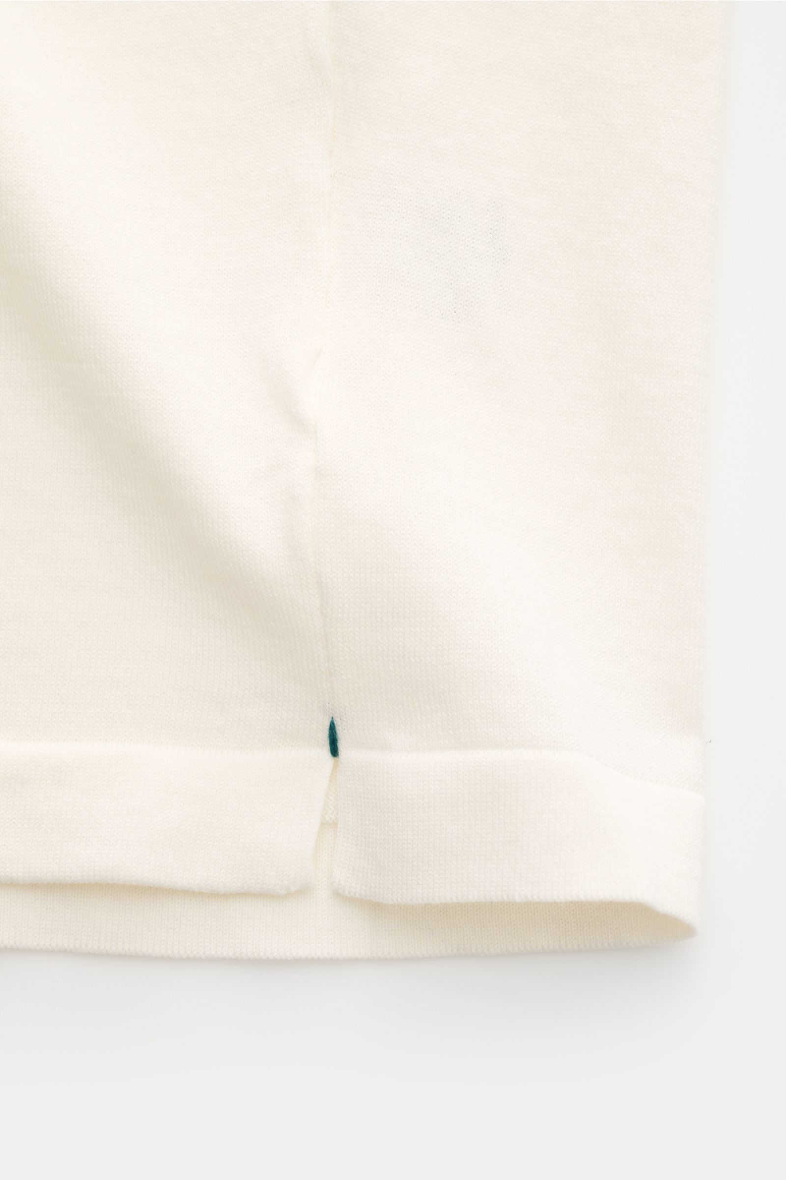 Close-up of the hem with short side slits of the Fioroni Rundhals-T-Shirt offwhite, finely knitted from pure cotton.

Für den gediegenen Auftritt im Frühling sorgt dieses fein gestrickte T-Shirt von FIORINI, welches aus reiner Baumwolle gefertigt wurde