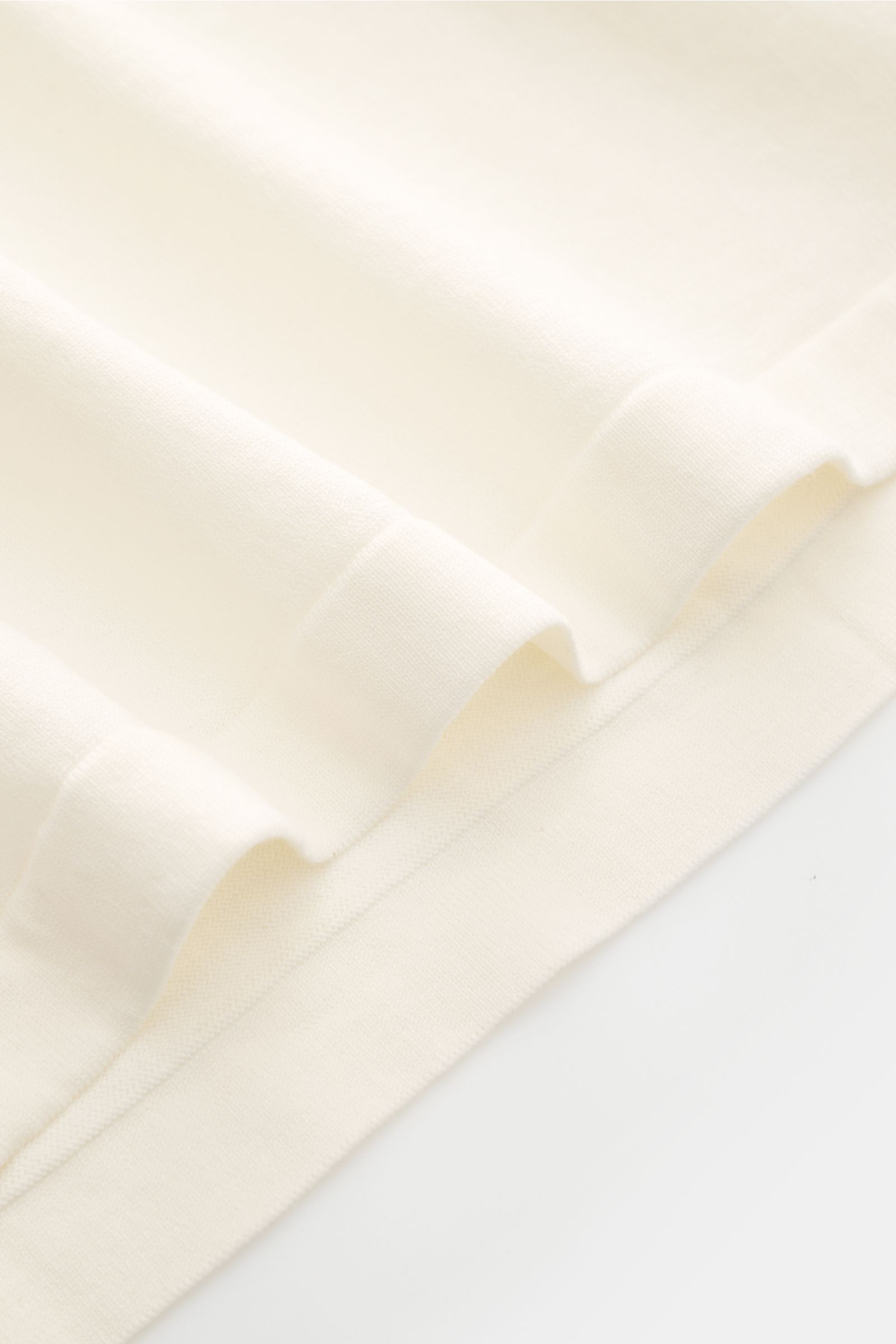 Close-up front view of the Fioroni Rundhals-T-Shirt offwhite showing fine knit, soft pure cotton fabric, slim fit, round neckline, and short hem slits.

Für den gediegenen Auftritt im Frühling sorgt dieses fein gestrickte T-Shirt von FIORINI, welches a