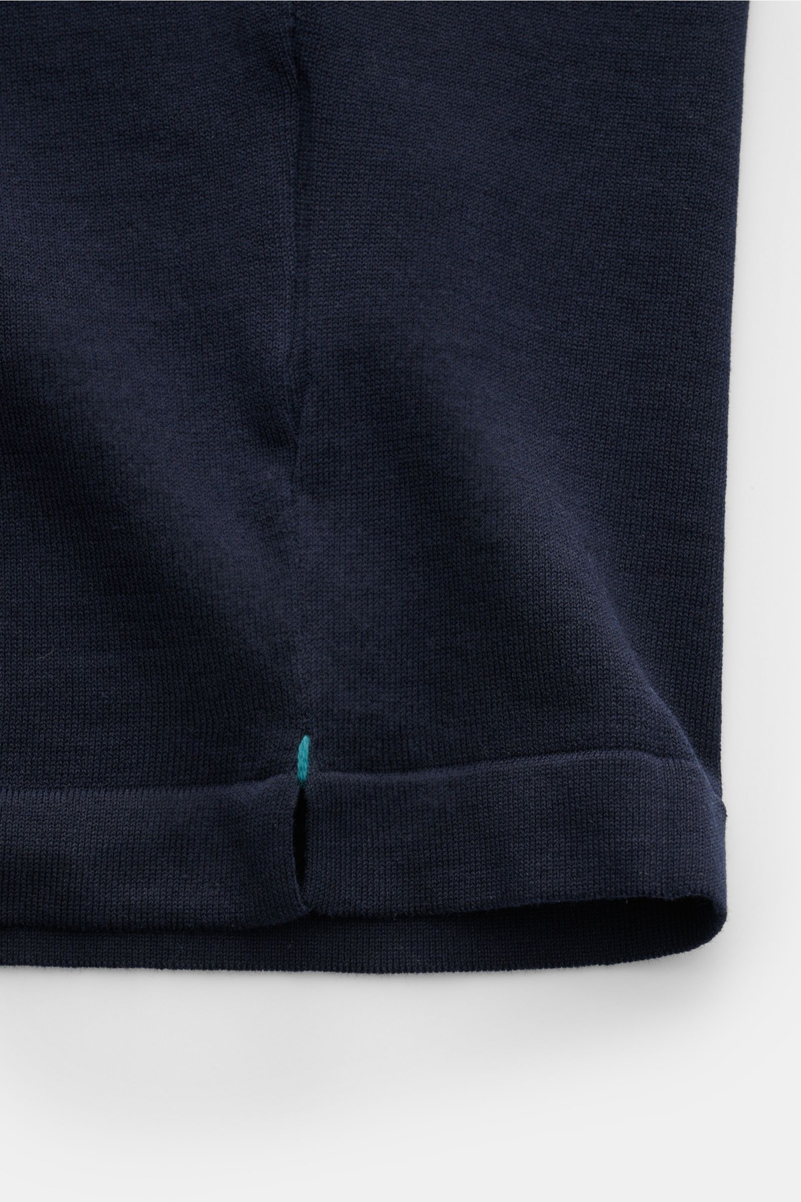 Close-up front view of the hem of the Fioroni Rundhals-T-Shirt navy showing fine knit fabric, hand-stitched detail, and short side slits.

Für den gediegenen Auftritt im Frühling sorgt dieses fein gestrickte T-Shirt von FIORINI, welches aus reiner Baum