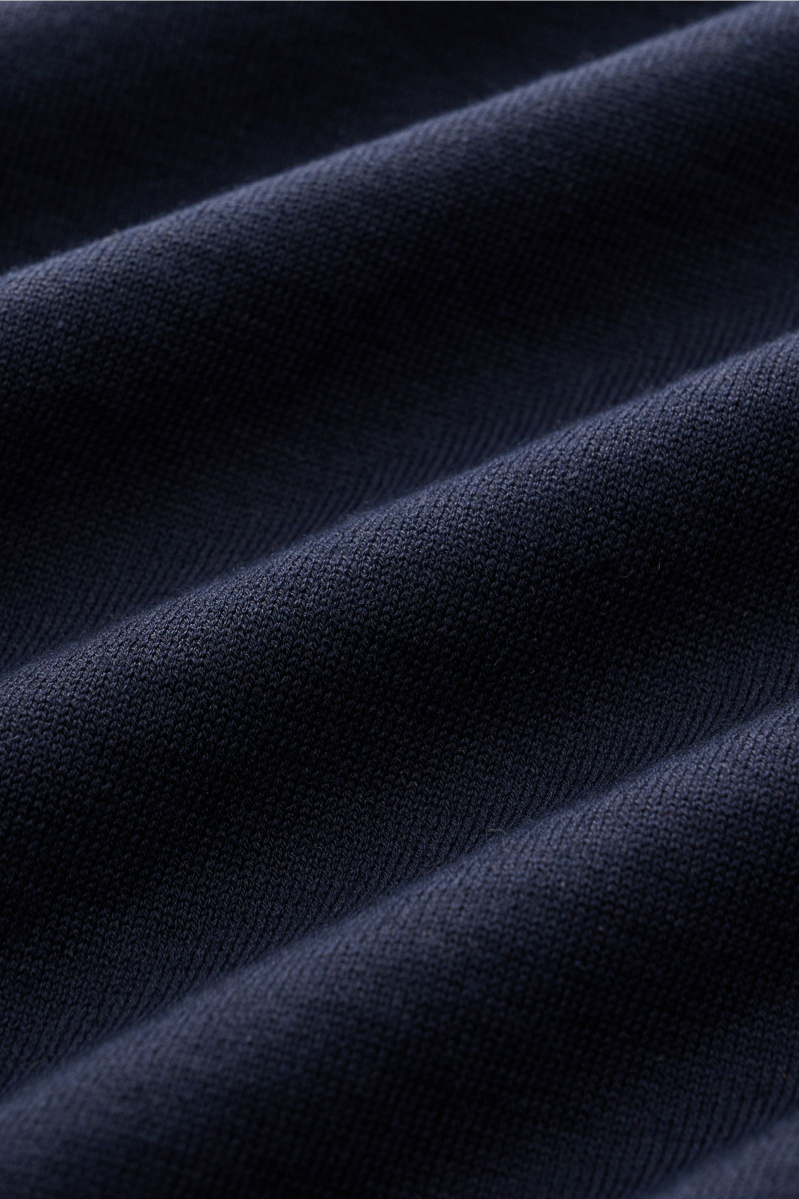 Close-up front angle of Fioroni Rundhals-T-Shirt navy showing fine knit texture and navy cotton fabric folds, soft touch.

Description: Für den gediegenen Auftritt im Frühling sorgt dieses fein gestrickte T-Shirt von FIORINI, welches aus reiner Baumwol