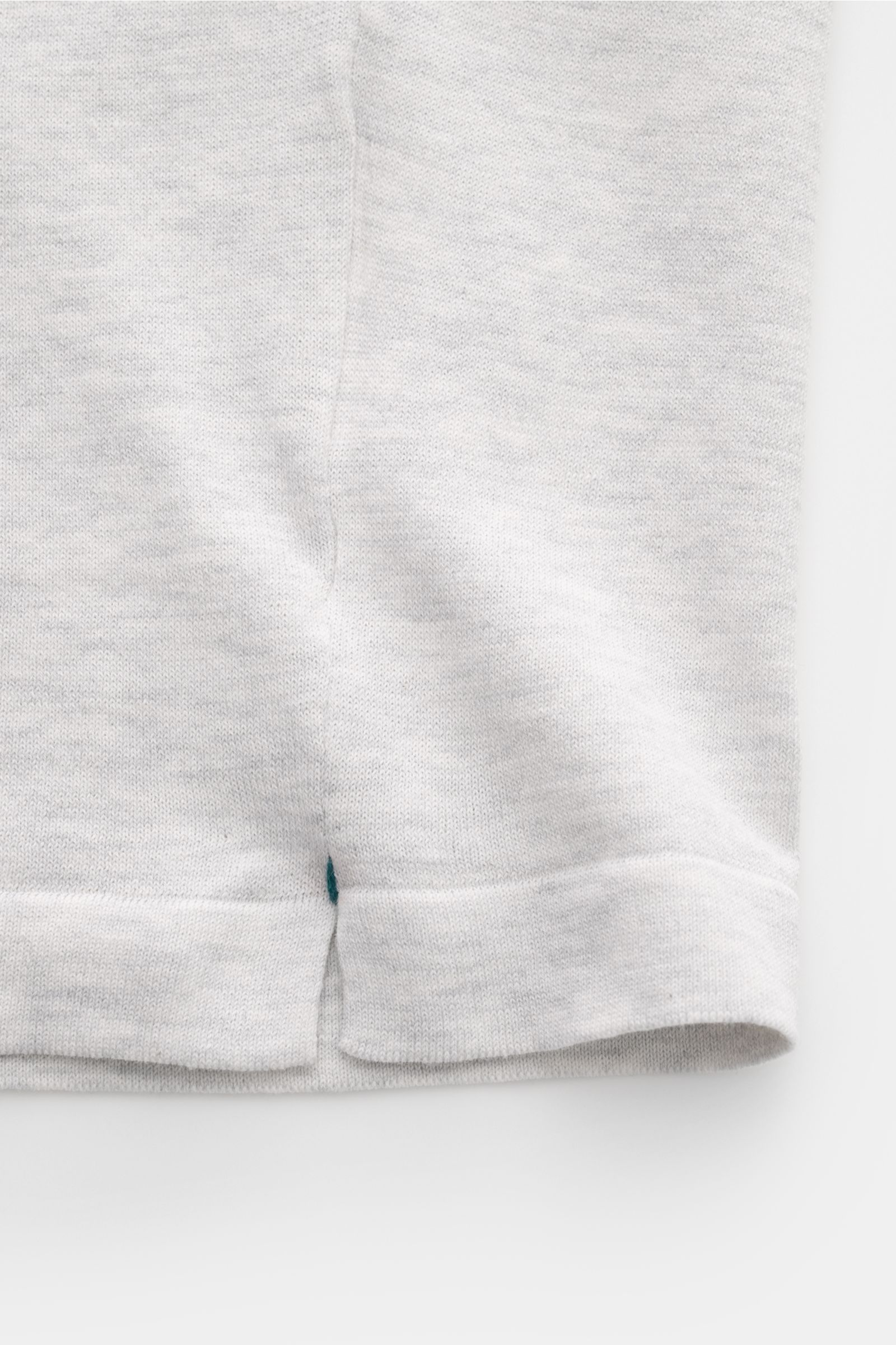 Close-up view of the hem with short side slits of the Fioroni Rundhals-T-Shirt hellgrau meliert, made of fine knitted pure cotton.

Für den gediegenen Auftritt im Frühling sorgt dieses fein gestrickte T-Shirt von FIORINI, welches aus reiner Baumwolle g