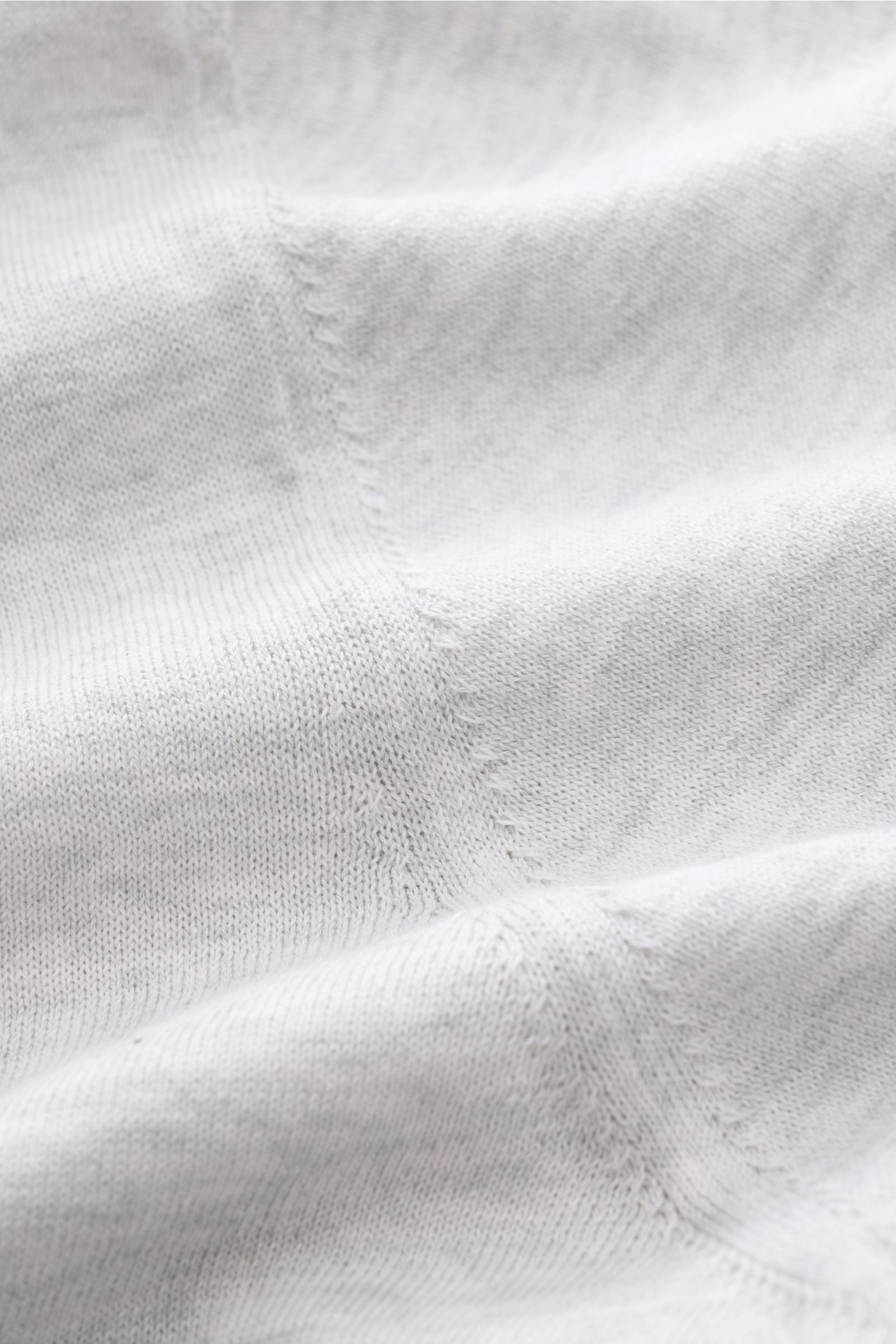 Close-up front view of Fioroni Rundhals-T-Shirt hellgrau meliert showing fine knit pure cotton fabric with handmade stitching details.

Für den gediegenen Auftritt im Frühling sorgt dieses fein gestrickte T-Shirt von FIORINI, welches aus reiner Baumwol