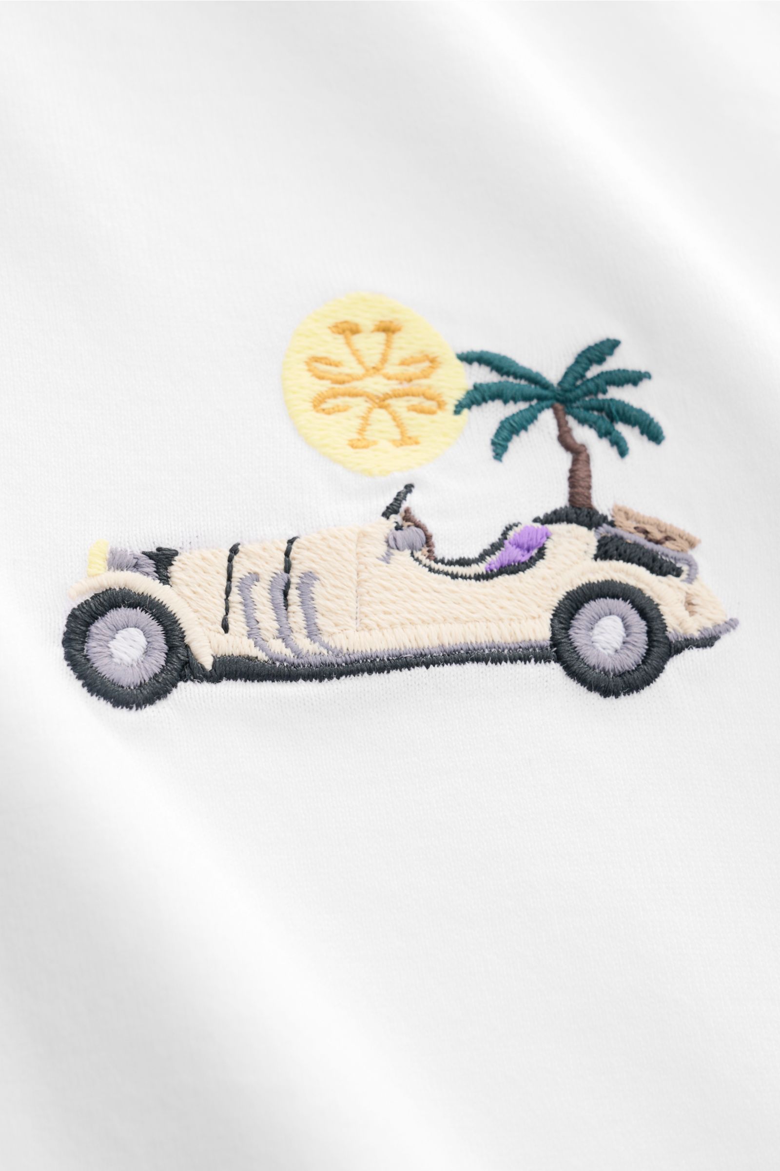 Close-up front view of Jacob Cohen Crew neck T-shirt 'Resort' white featuring intricate embroidery of a vintage car, palm tree, and sun on soft cotton fabric.

For its 'Resort' collection, JACOB COHEN has chosen a classic cotton T-shirt enhanced with h