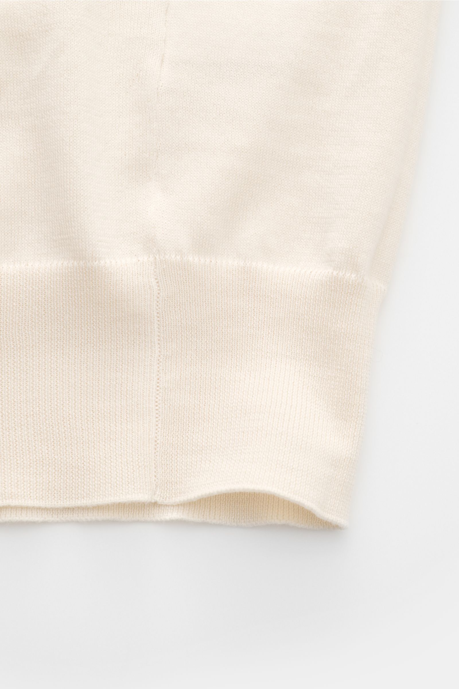 Close-up front view of the hem of the Brunello Cucinelli Kurzarmpullover creme, showing fine cotton knit with slim fit and narrow contrast edges.

Dieser zeitlose, vielseitige Kurzarmpullover von BRUNELLO CUCINELLI aus reiner Baumwolle in feinstem Stri
